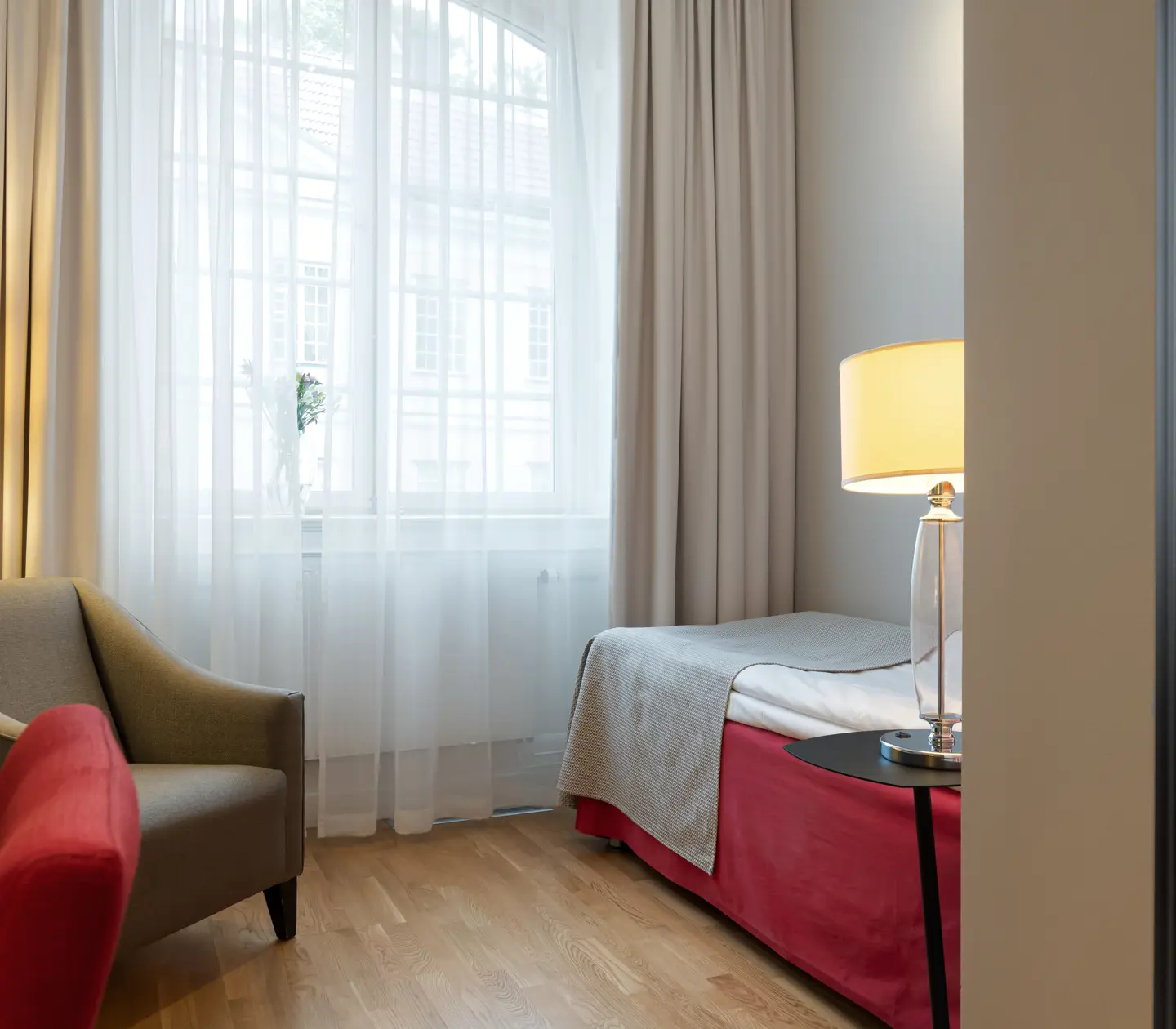 Hotel room with bed, armchair and window