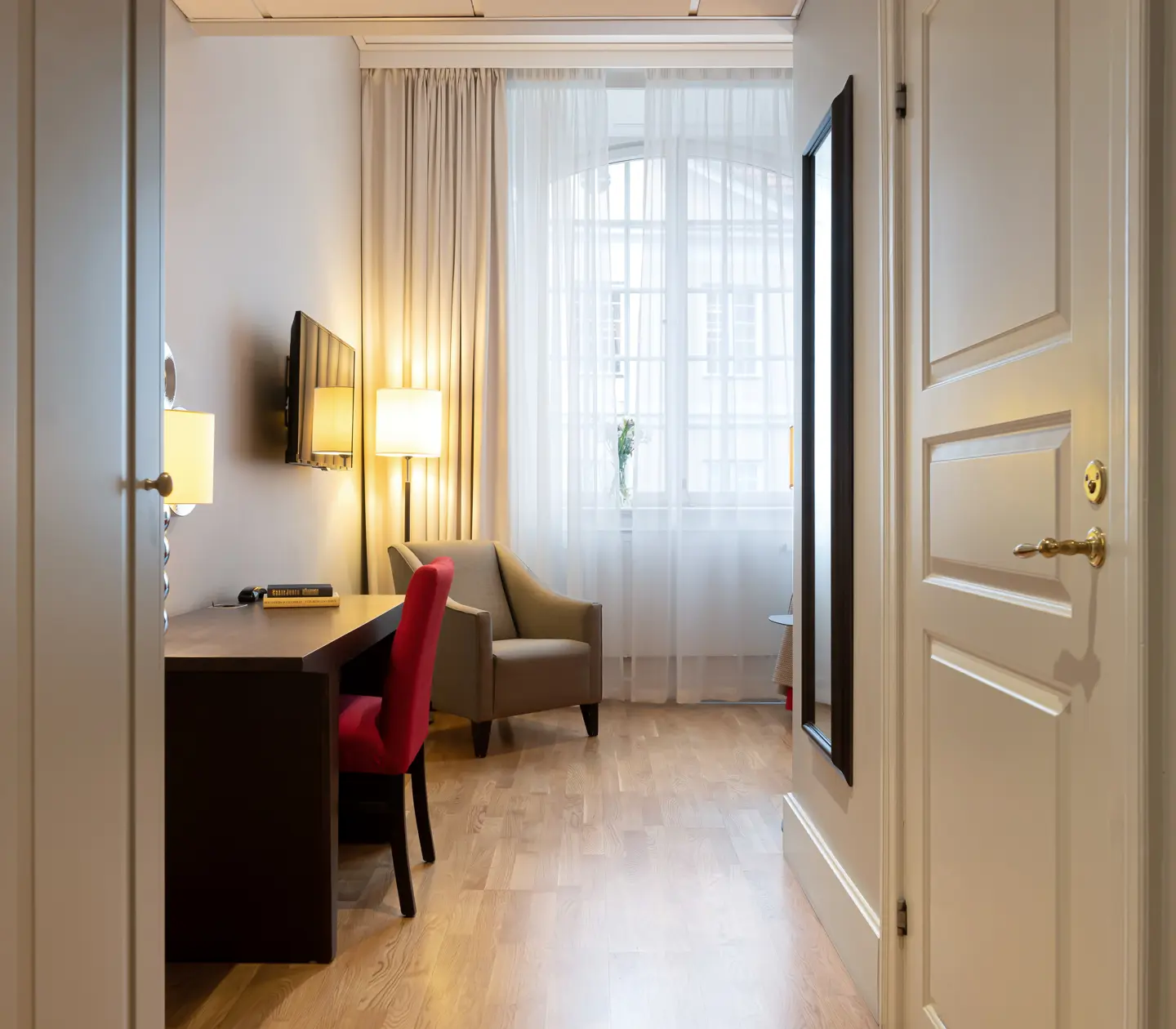 Hotel room with window, desk and armchair