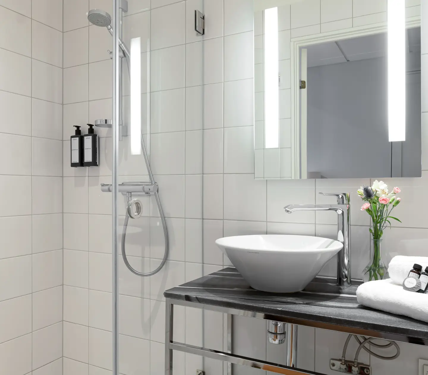 Bright bathroom with shower, sink and mirror