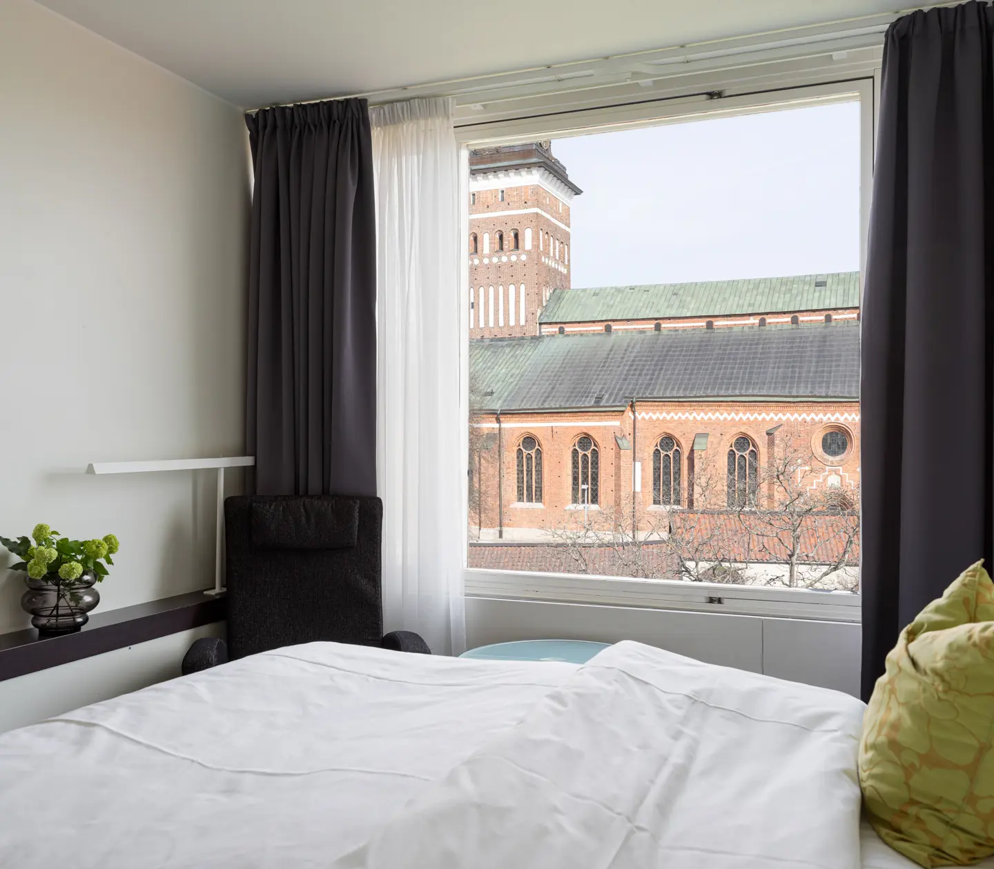 Mysigt hotellrum med säng, fåtöljer och skrivbord