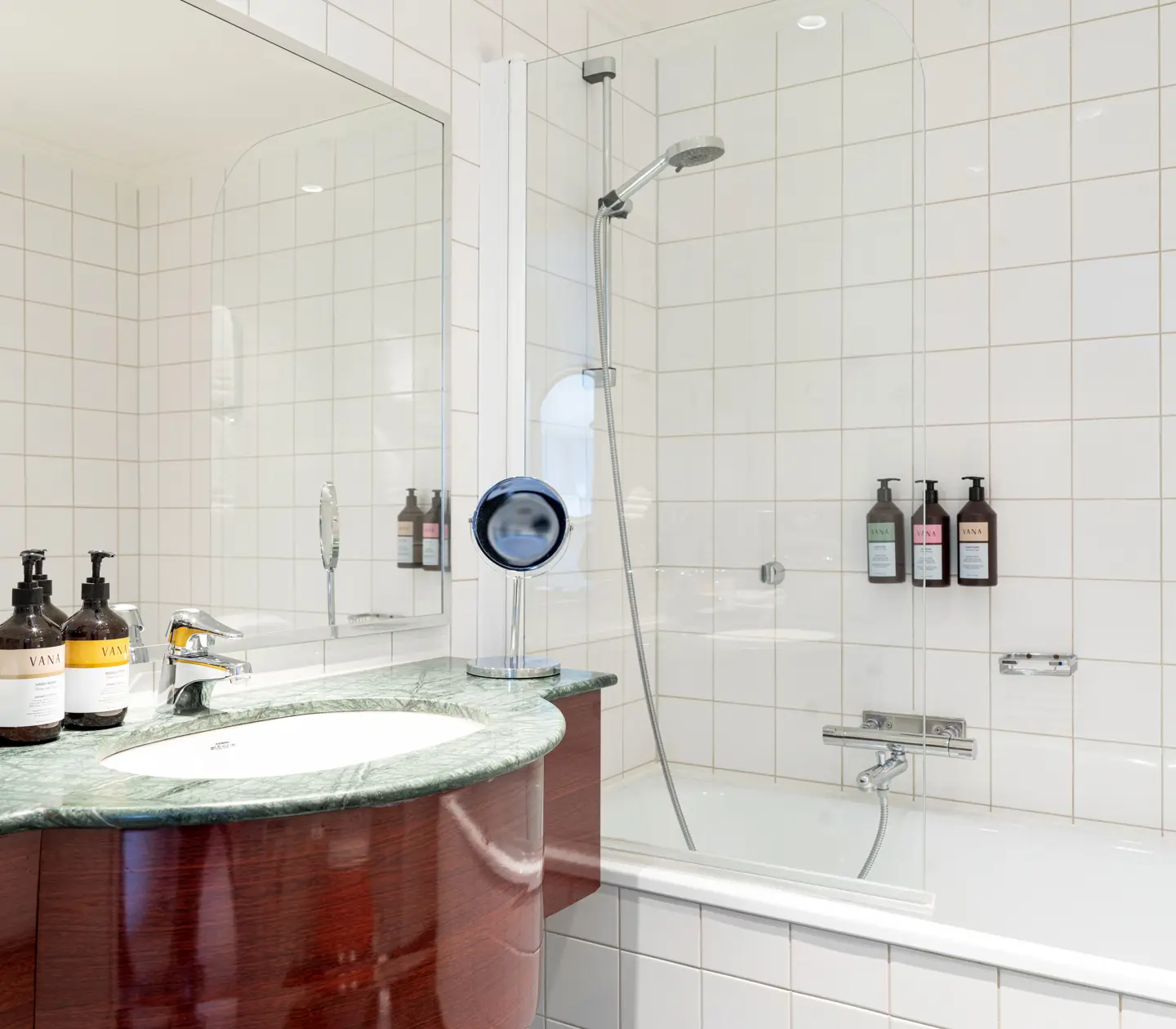 Mysigt hotellrum med morgonrock på säng, fönster och fåtöljer