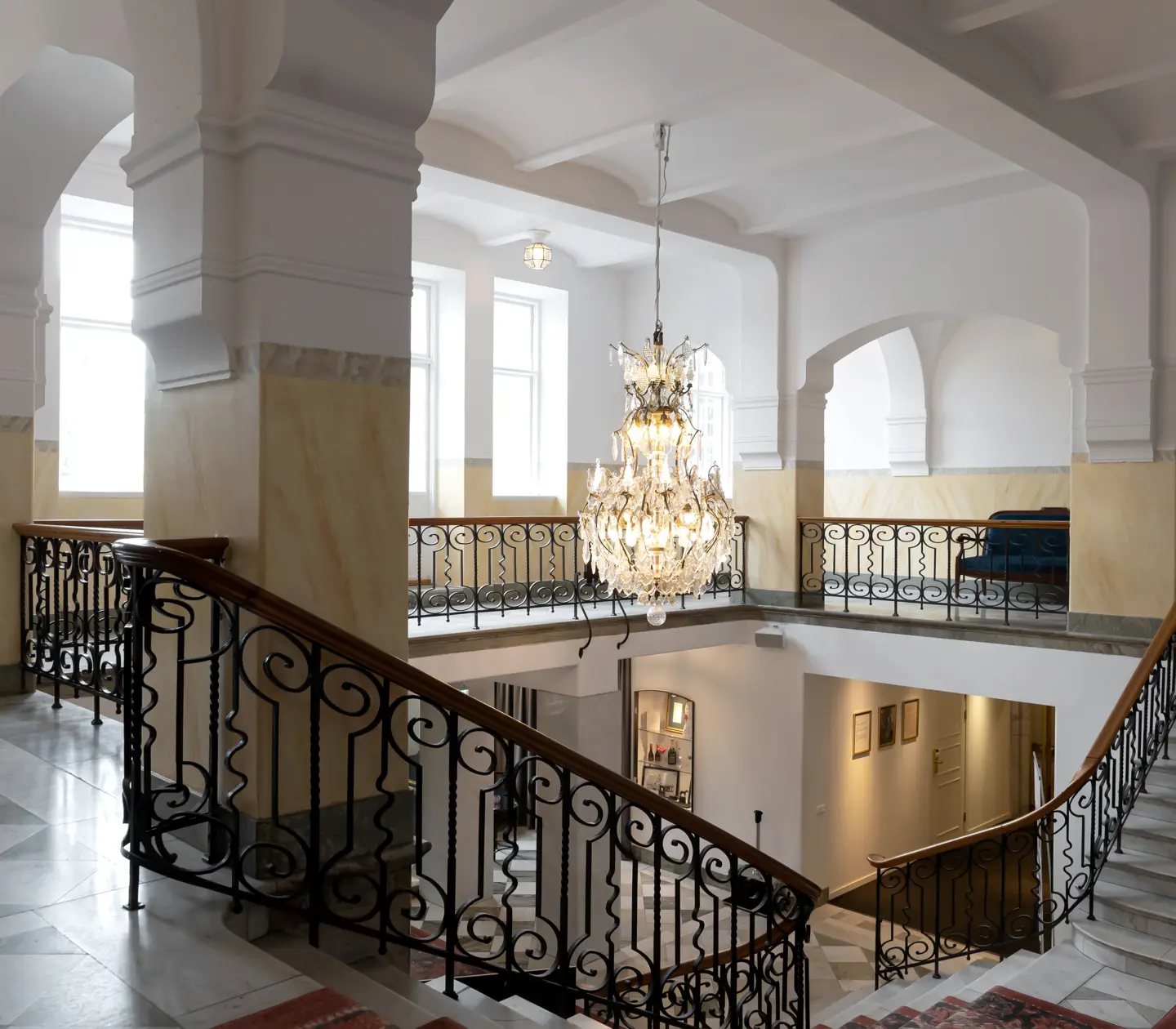 Hotel environment with stairs, arches and crystal chandelier