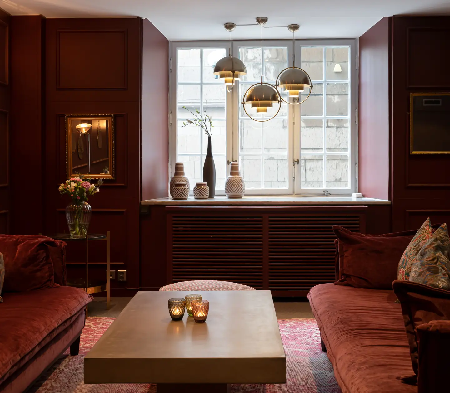 Hotel environment with burgundy walls, red sofas and windows
