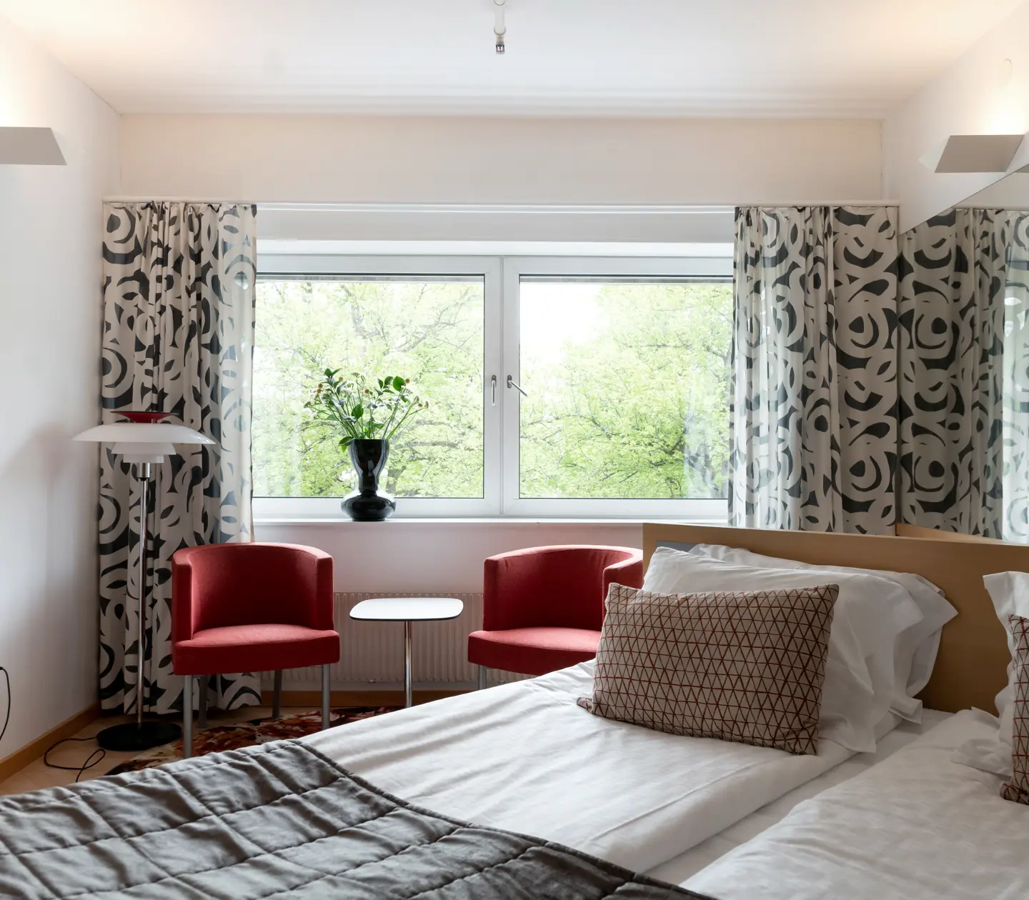 Hotel room with double bed, armchairs and window