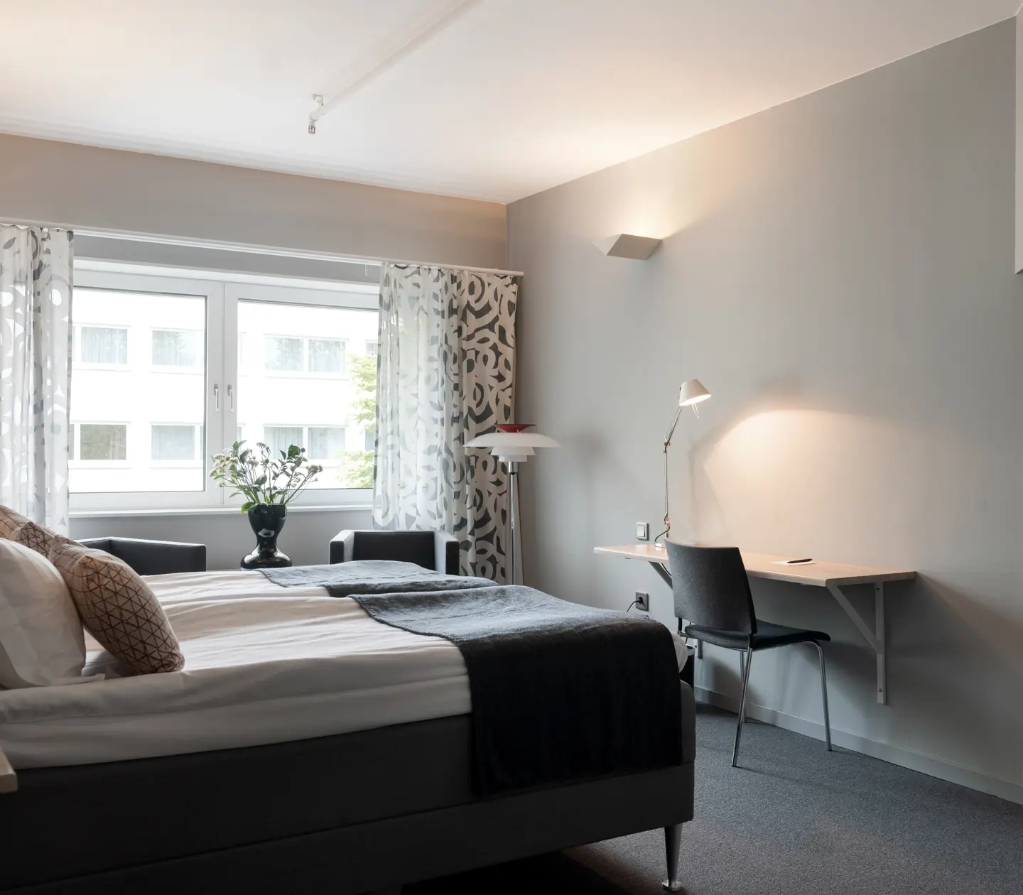 Bright hotel room with double bed, desk and window