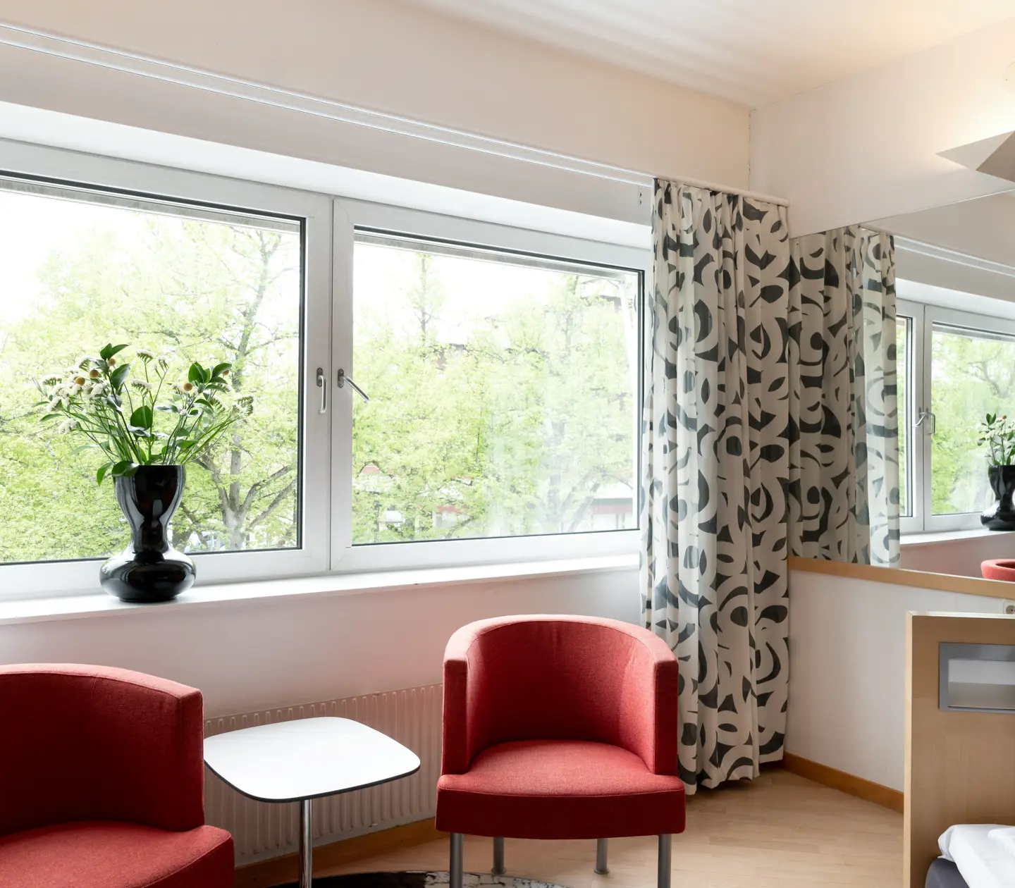 Hotel room with red armchairs and window