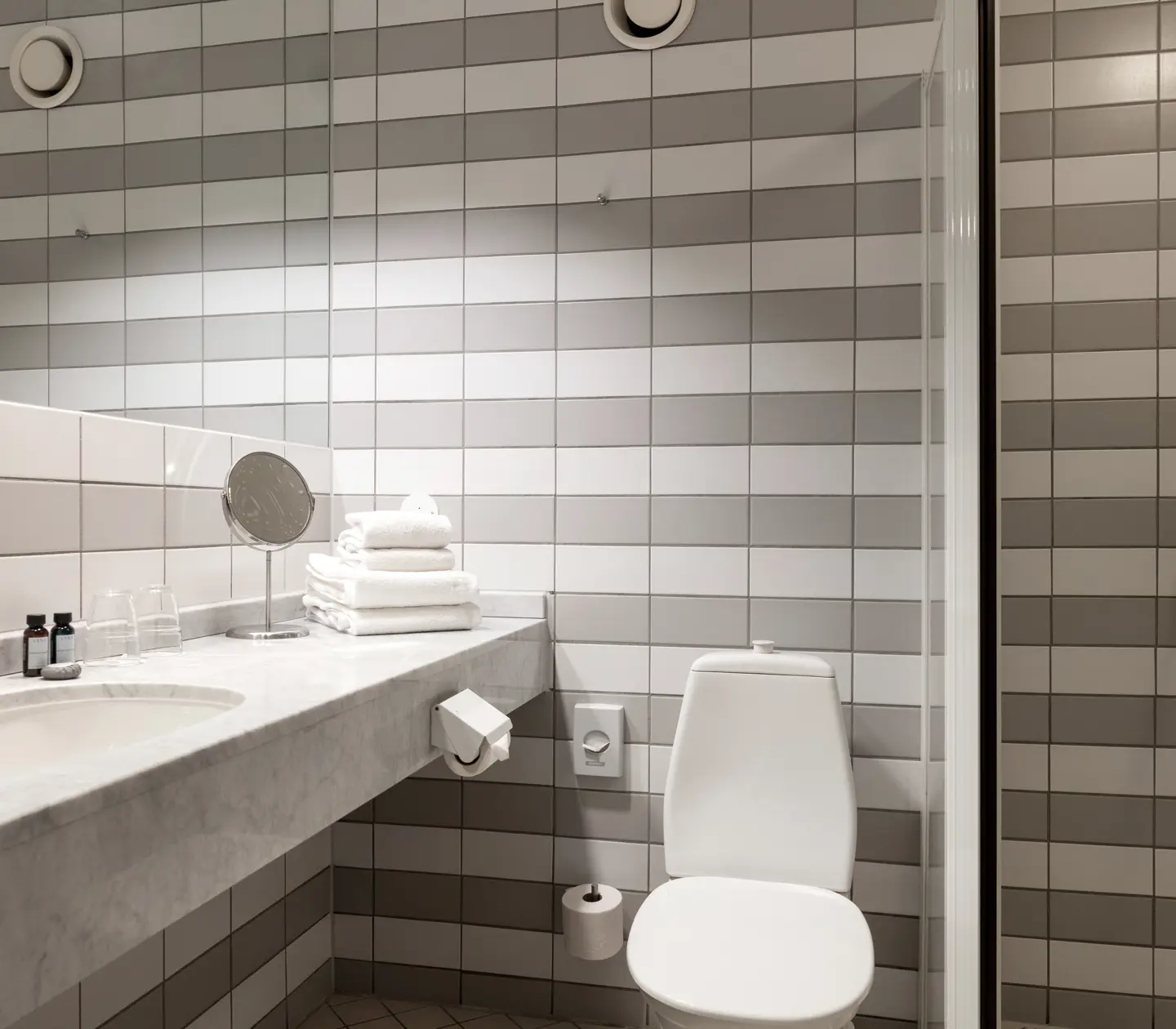 Bathroom with striped tiles, toilet and shower