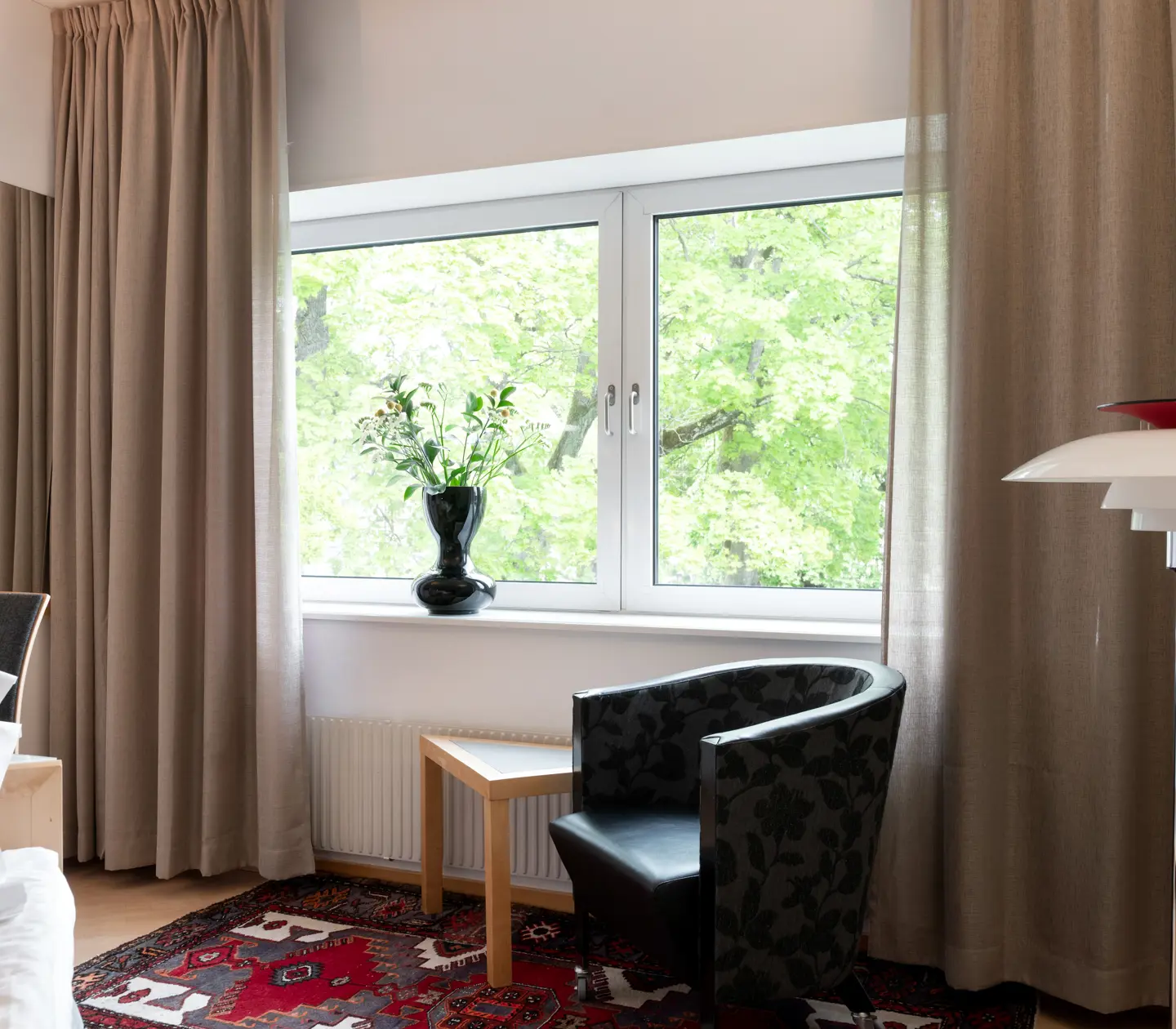 Hotel room with floor lamp, armchair and window