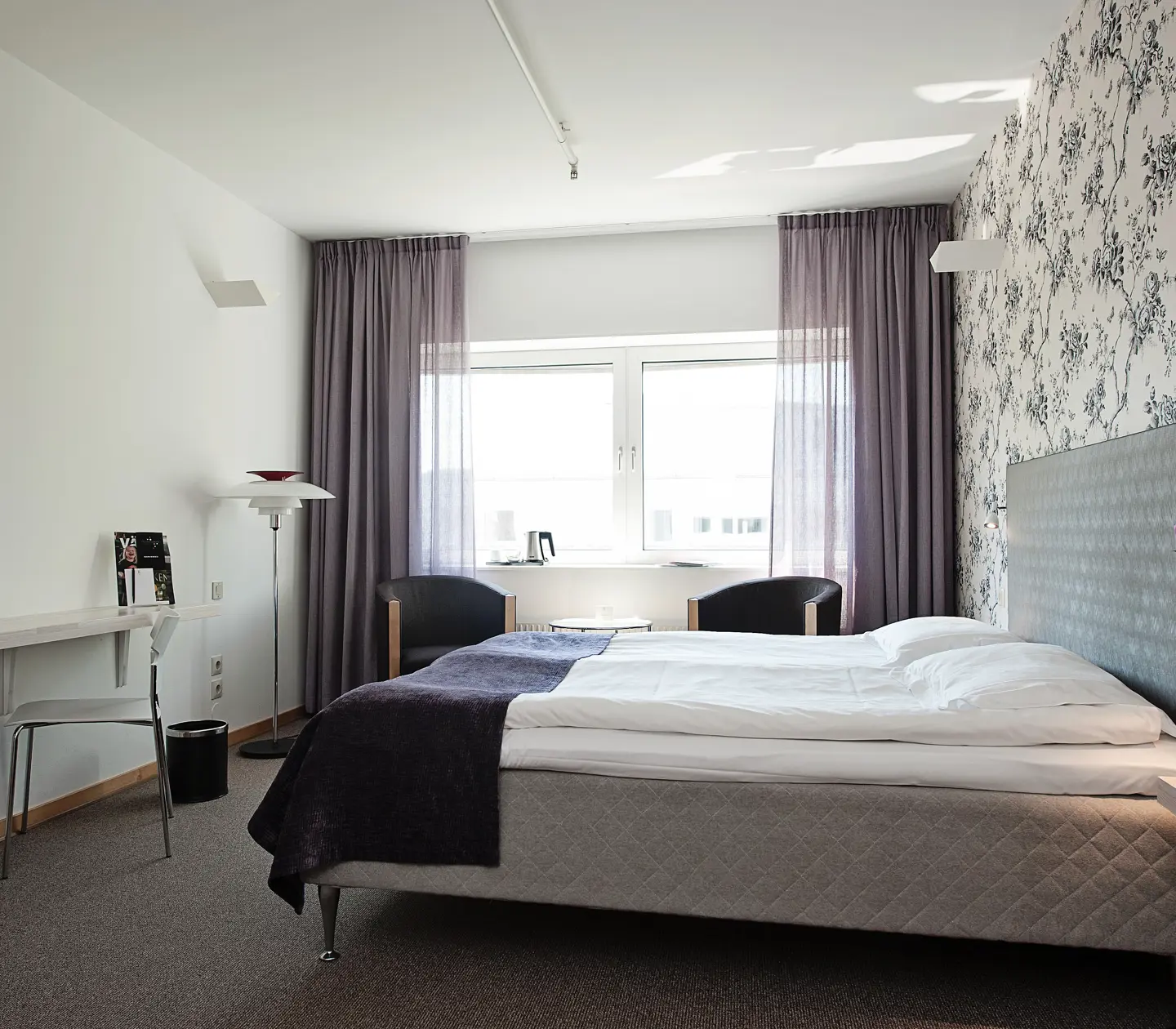 Bright hotel room with floral wallpaper