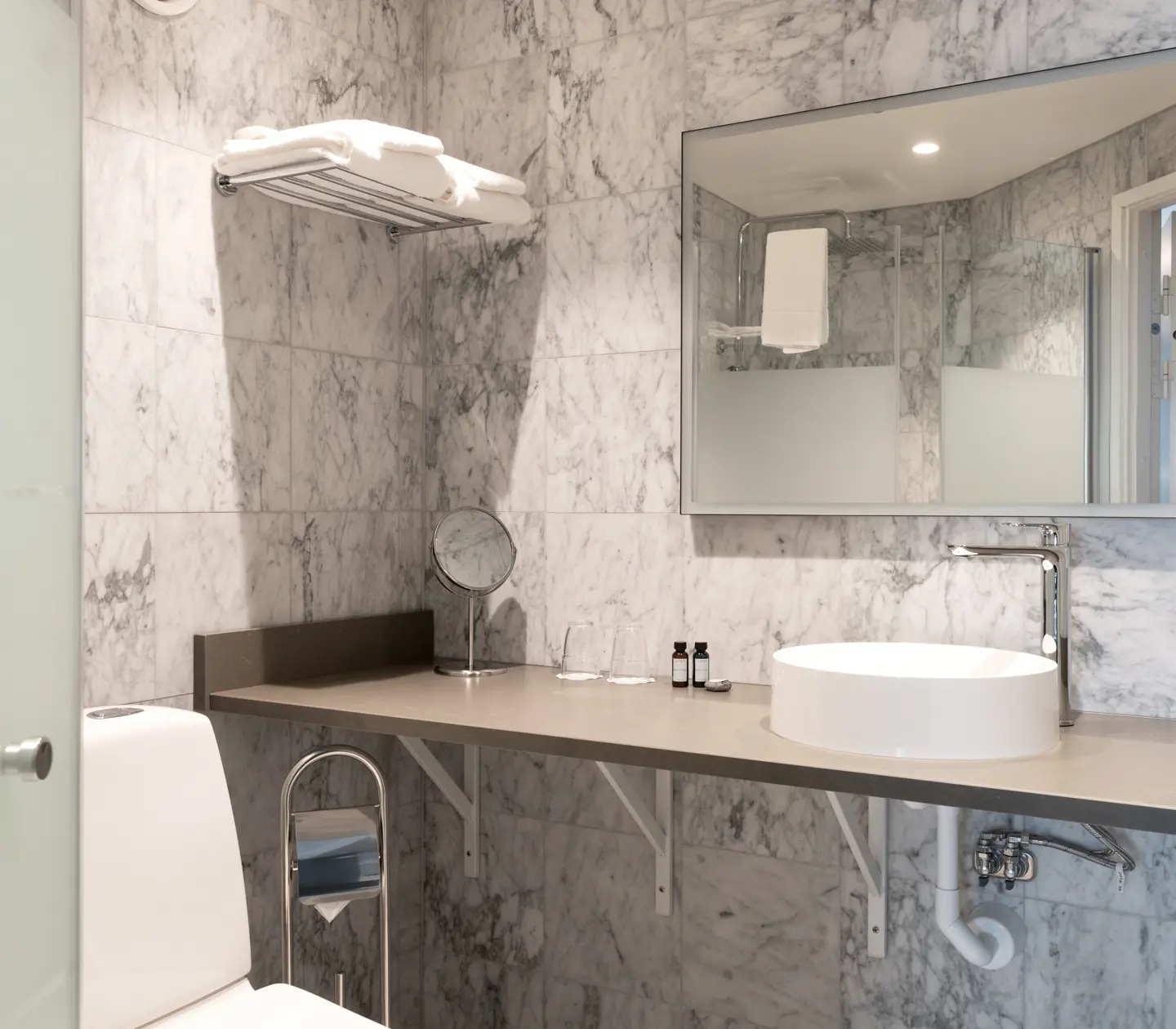 Marble tiled bathroom with sink and mirror