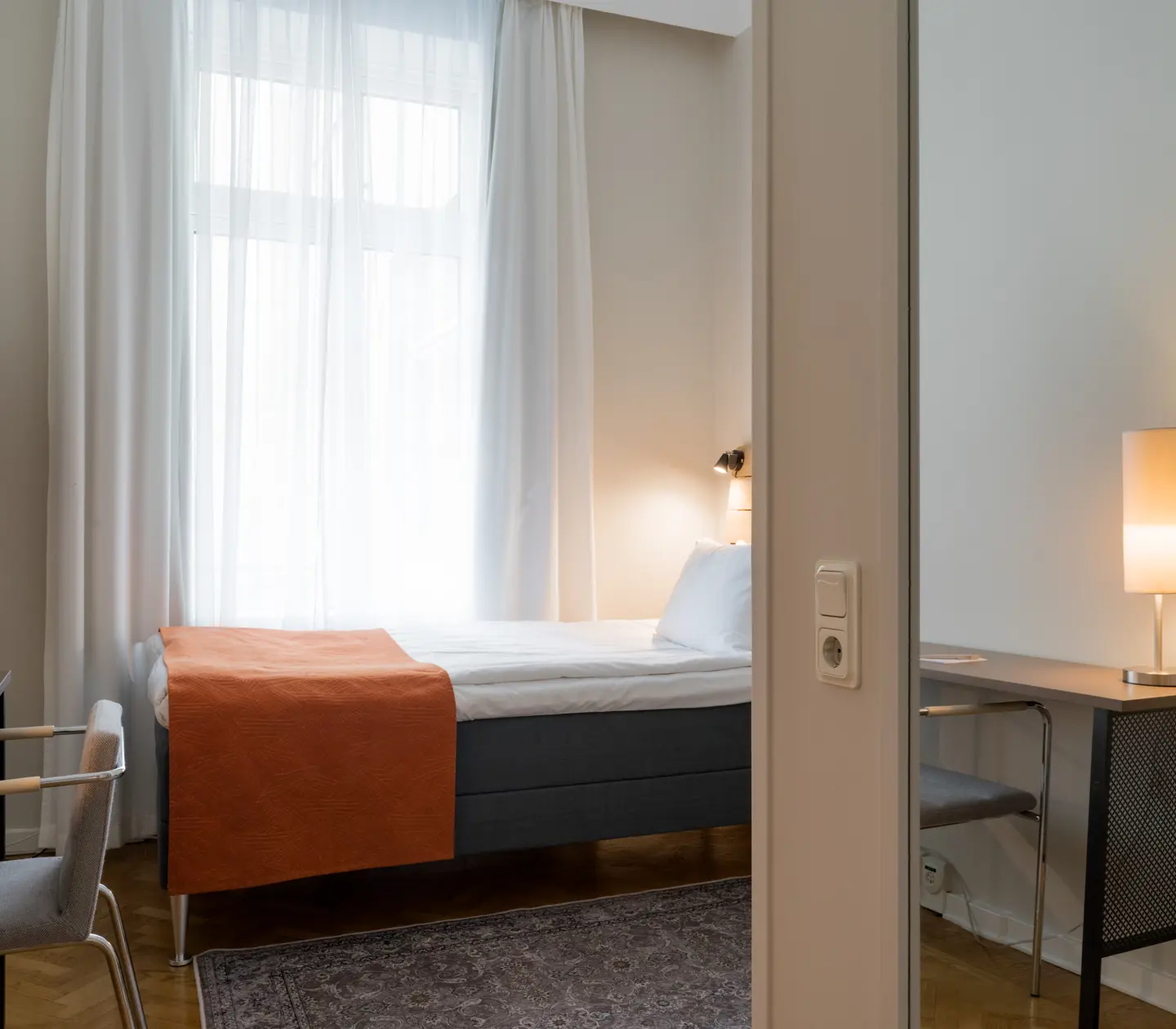 Cozy hotel room with single bed, desk and window
