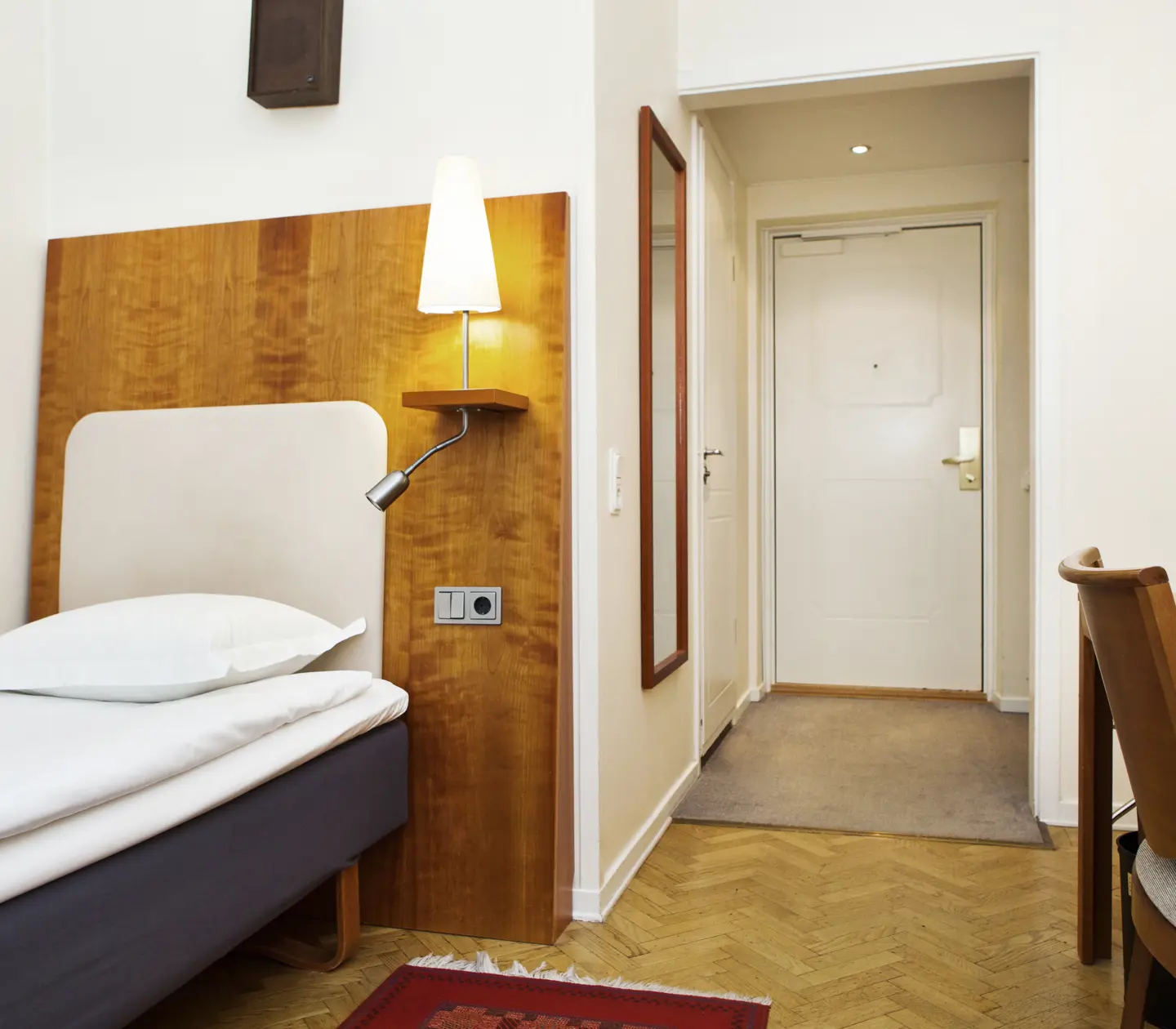 Hotel room with single bed and wooden headboard