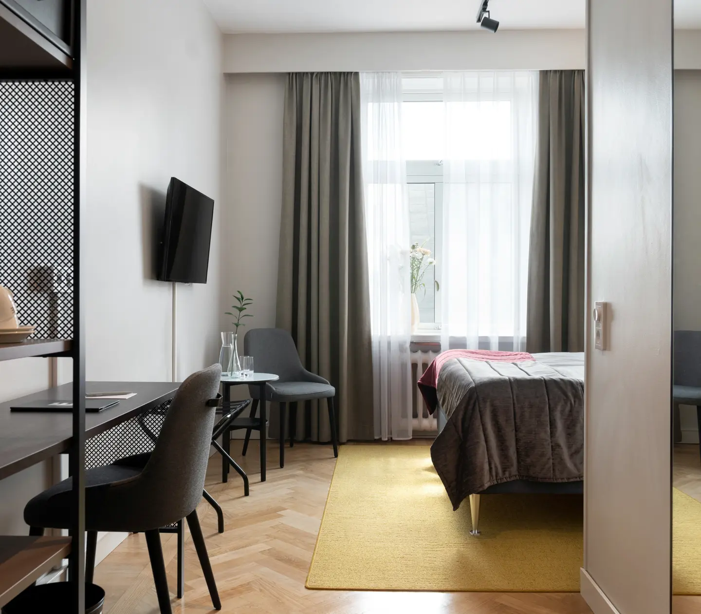 Hotel room with desk, armchair, TV and window