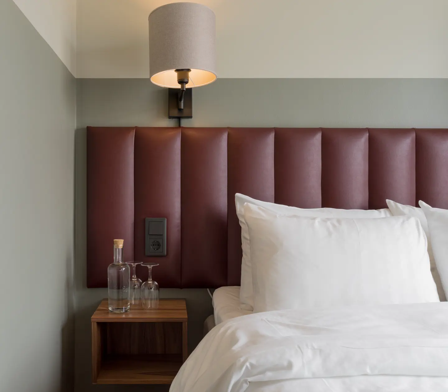 Close-up of double bed with red headboard