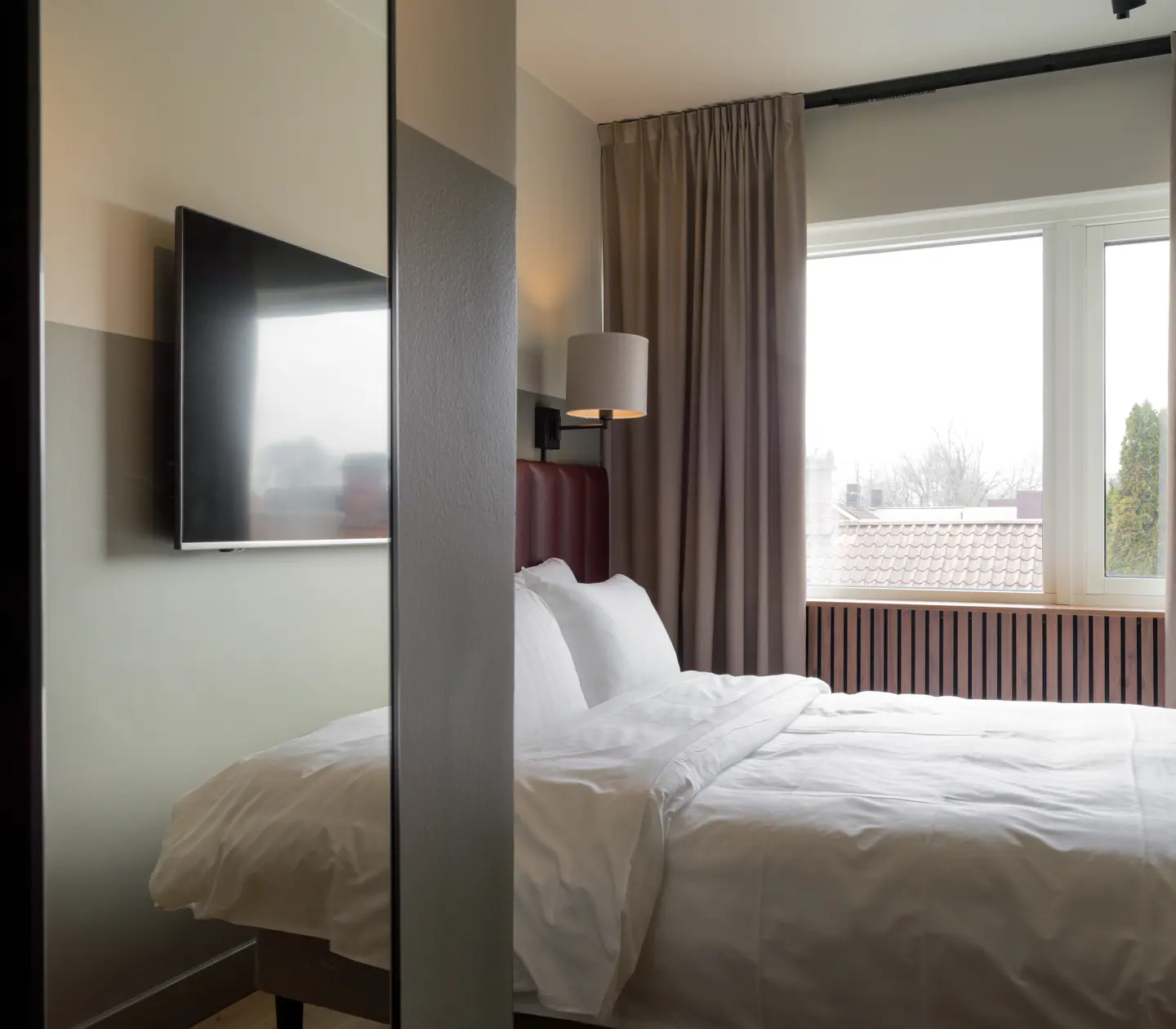 Hotel room with double bed, mirror and window