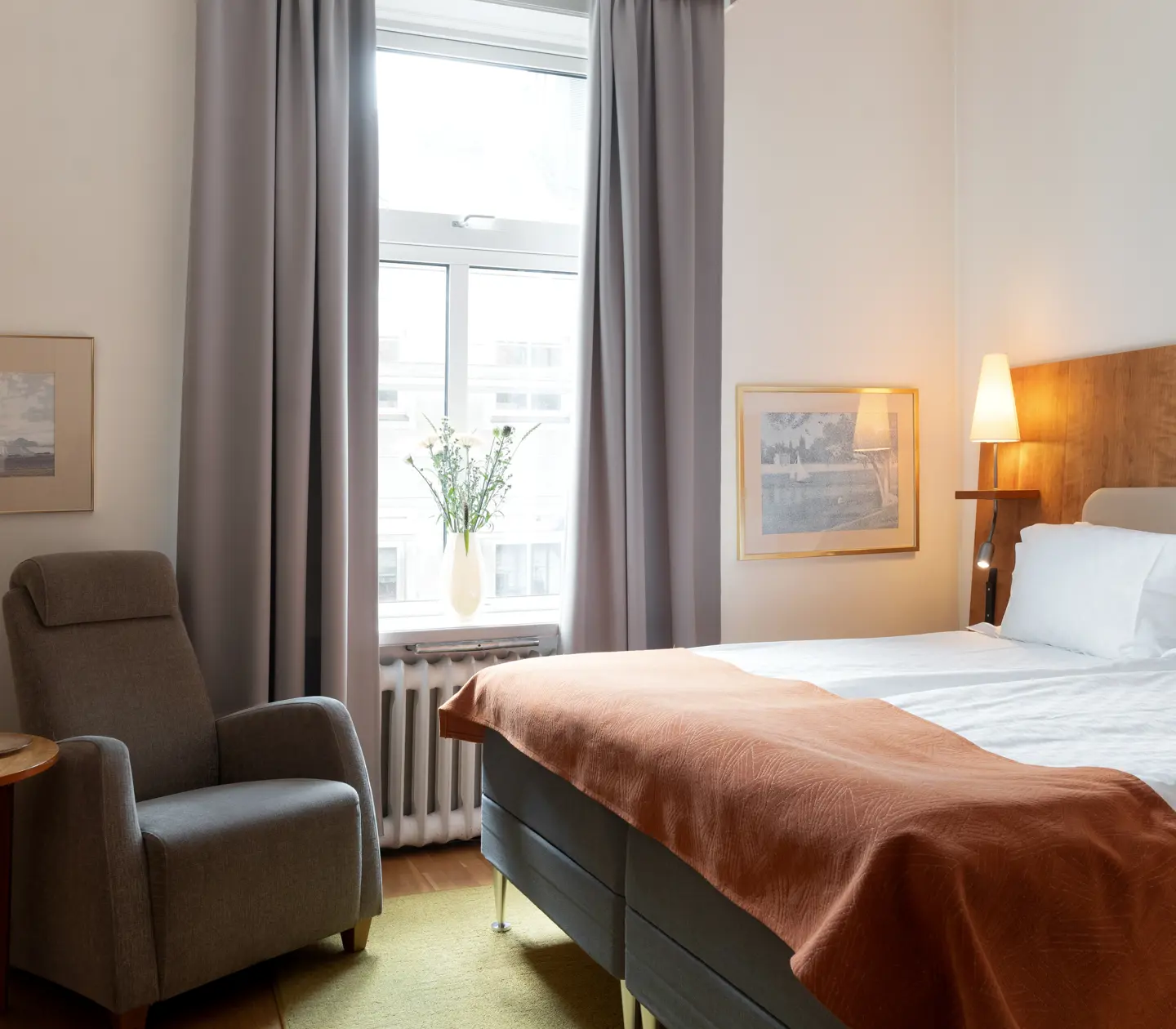 Cozy hotel room with double bed, armchair and window