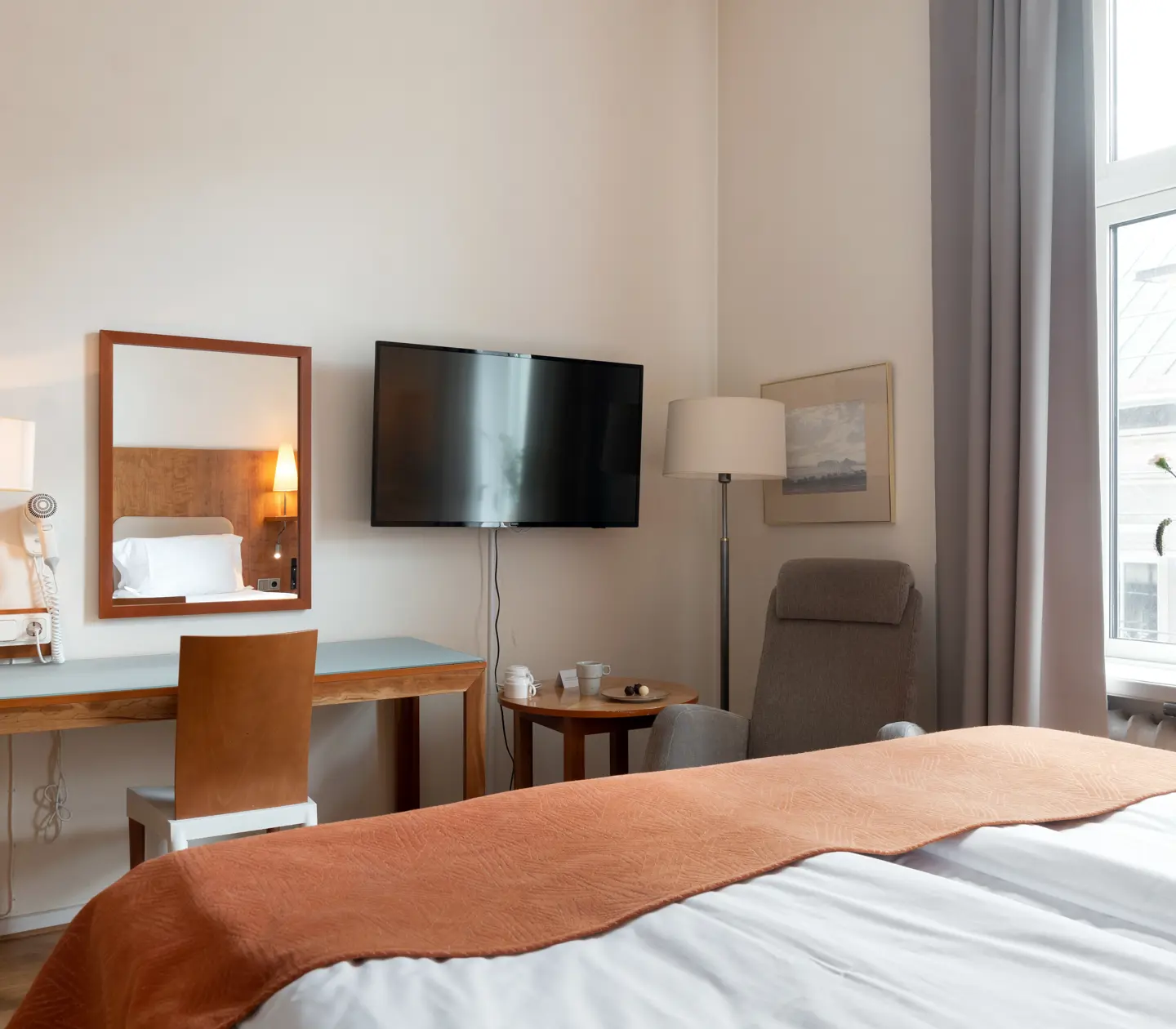 Cozy hotel room with desk, window and TV