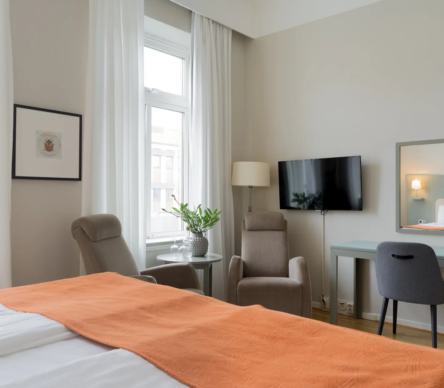 Cozy hotel room with armchairs, desk and TV