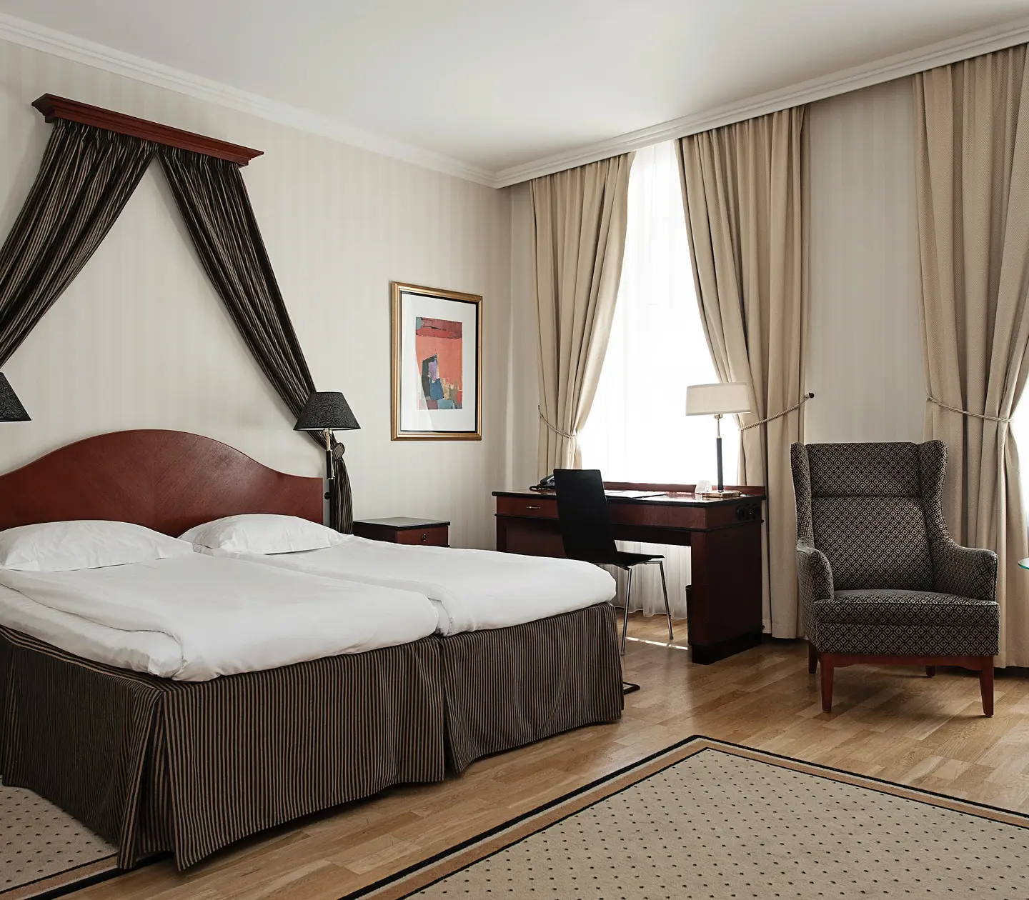 Hotel room with double bed, desk and curtains