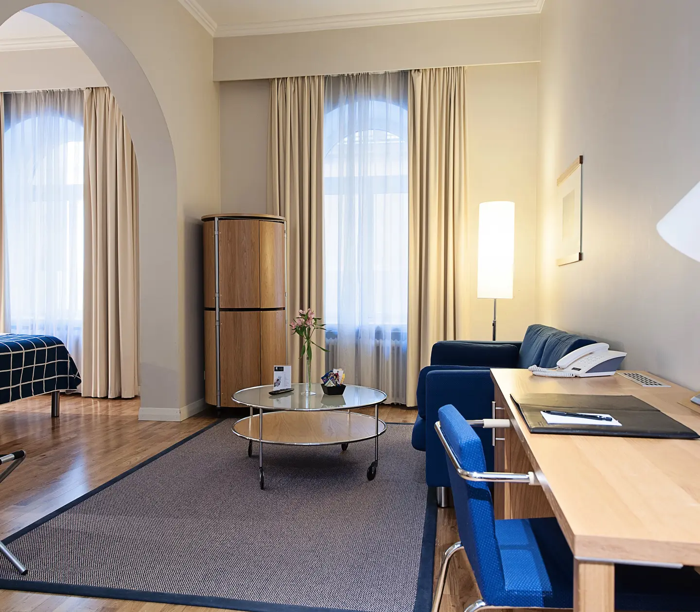 Bright hotel room with sofa, desk and window