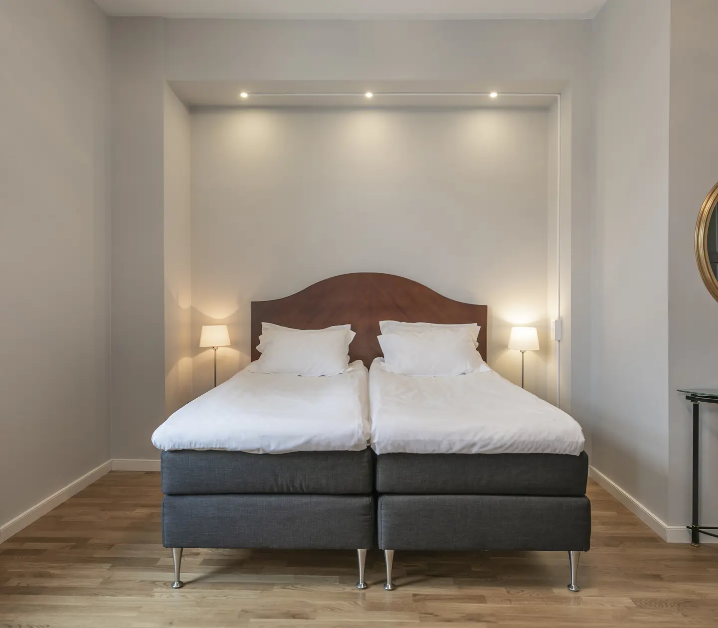 Hotel room with double bed in light frame and mirror