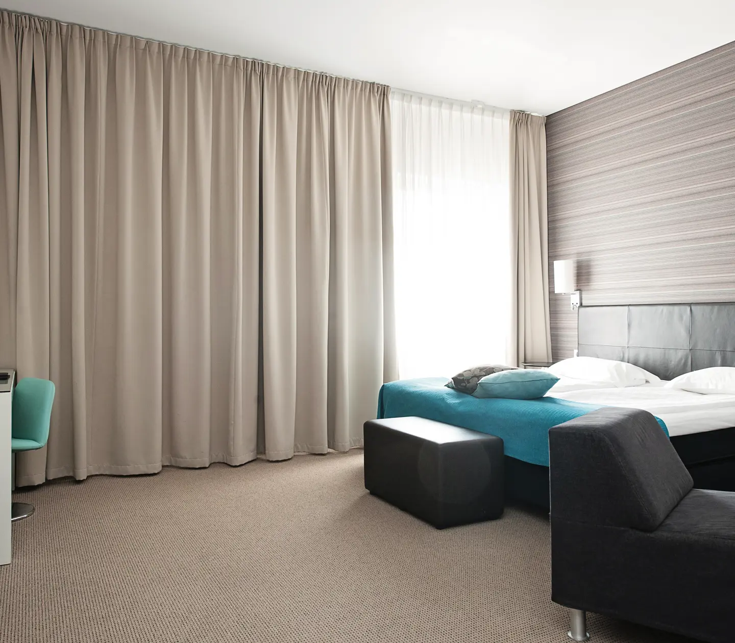 Hotel room with carpet, curtains and double bed