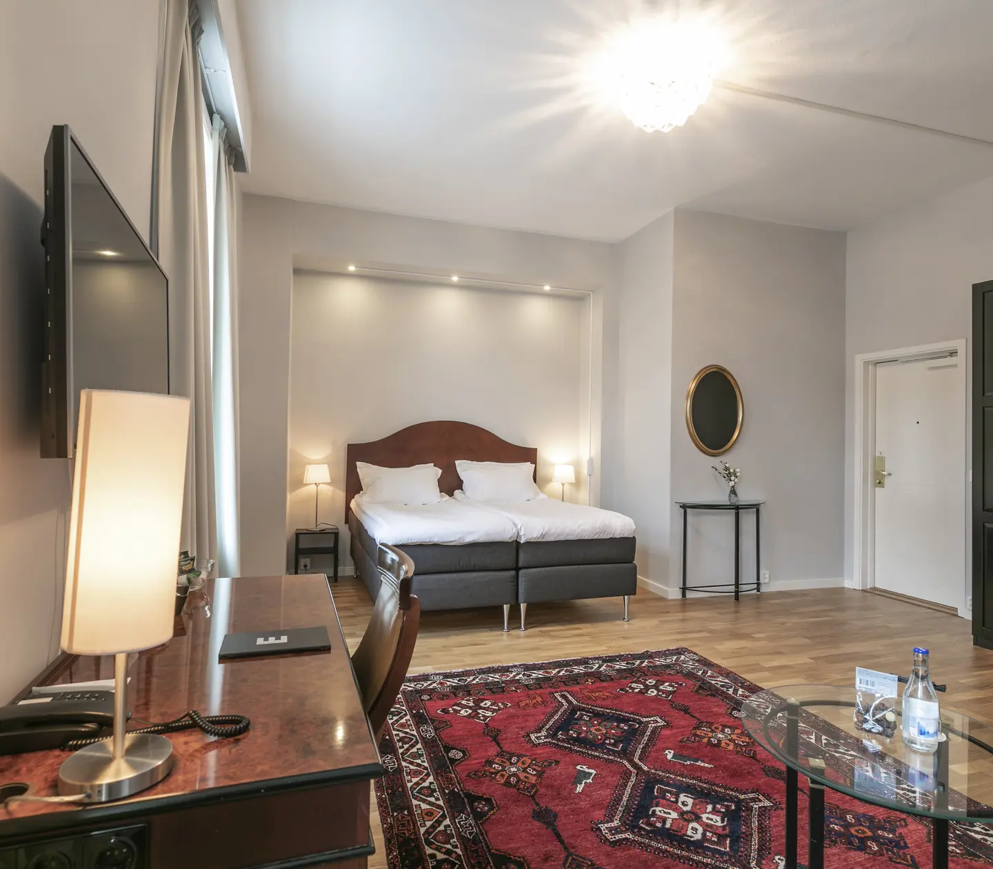 Hotel room with double bed, desk and wardrobe