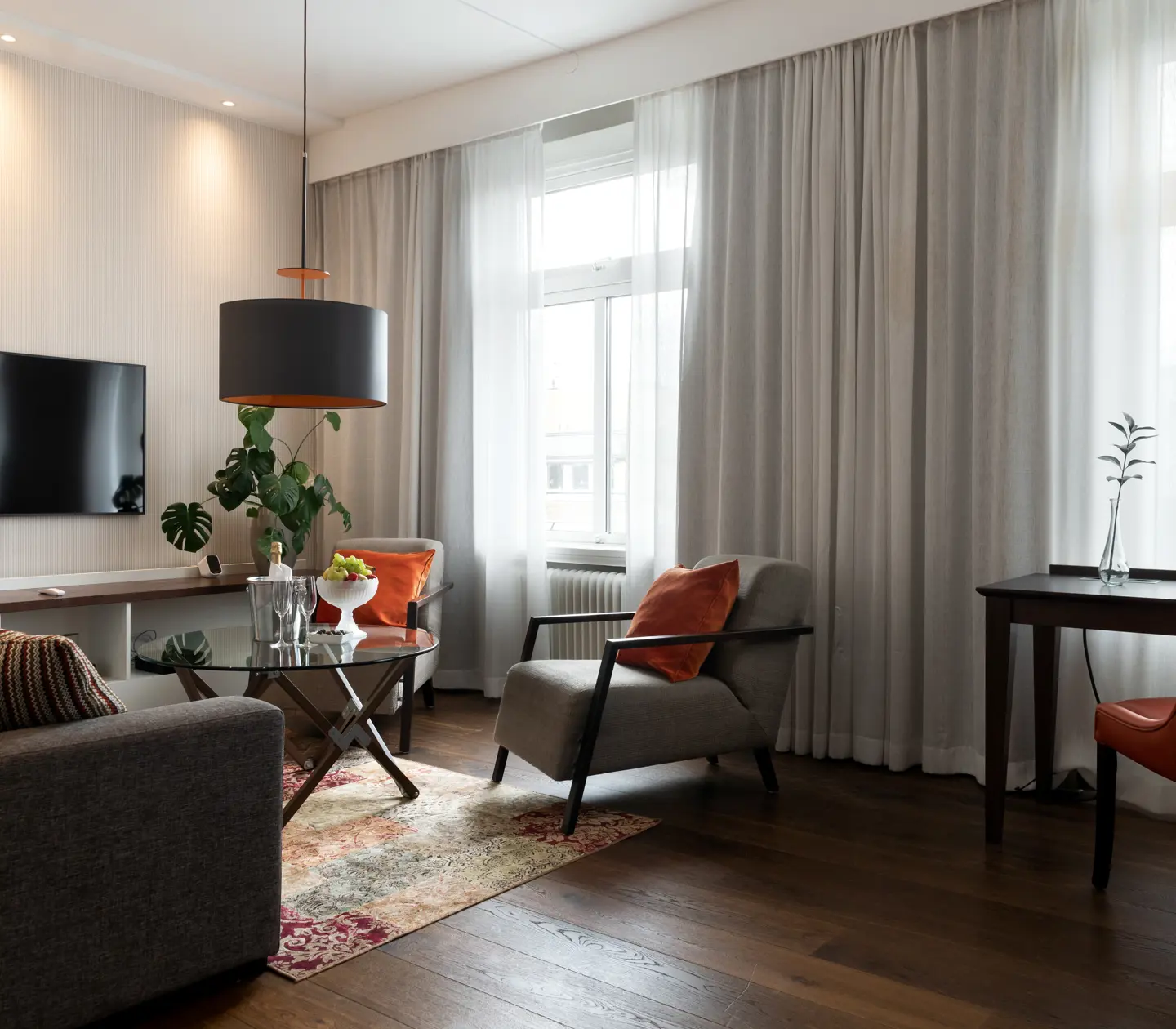 Suite with sofa group, TV and large windows
