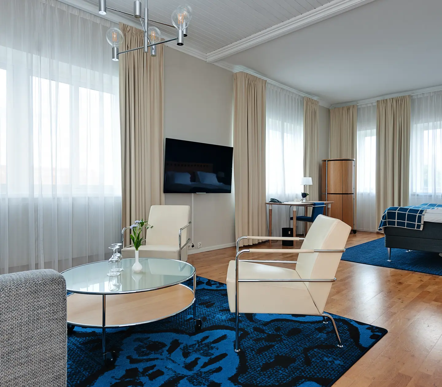 Suite with double bed, lounge furniture, TV and window