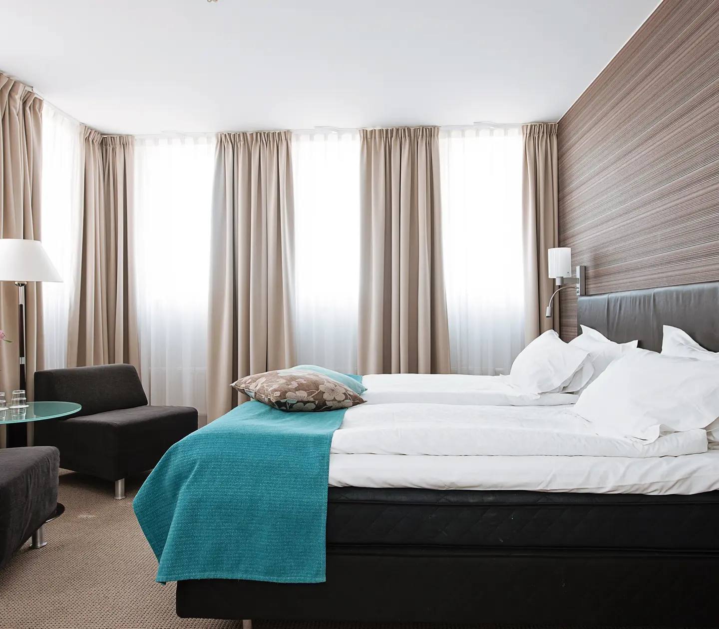 Suite with double bed, armchairs and many windows