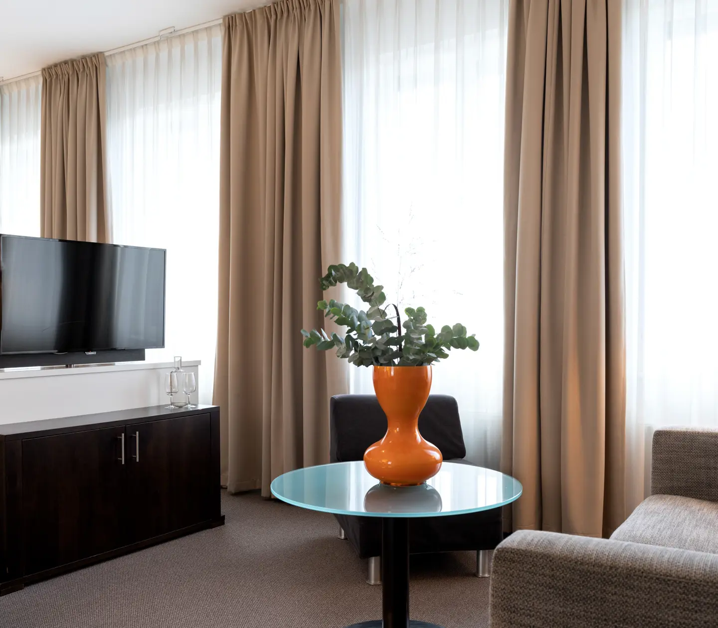 Suite with sofa, TV, bed and many windows