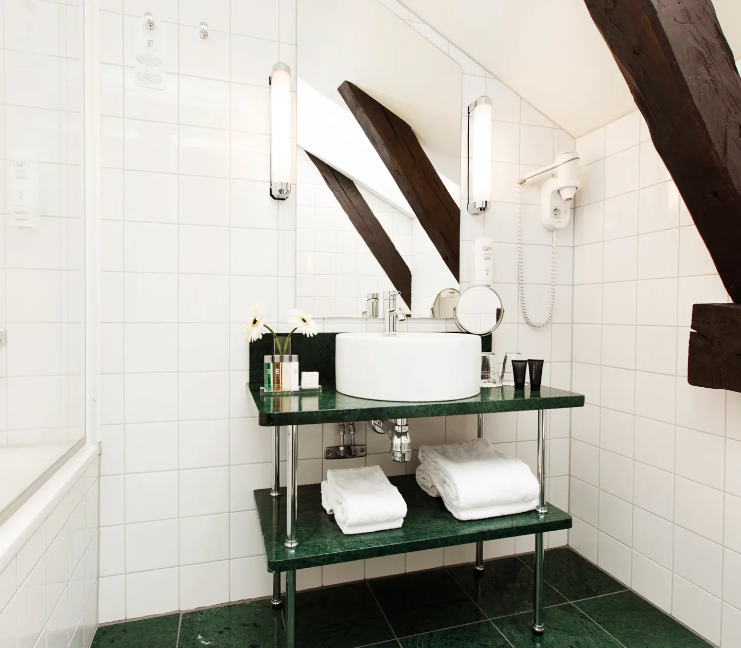 Bright bathroom with green floor, sink, bathtub and ceiling beams