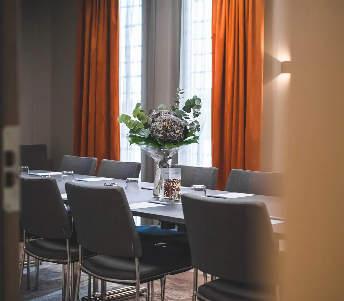 A conference room with a long table decorated with flowers