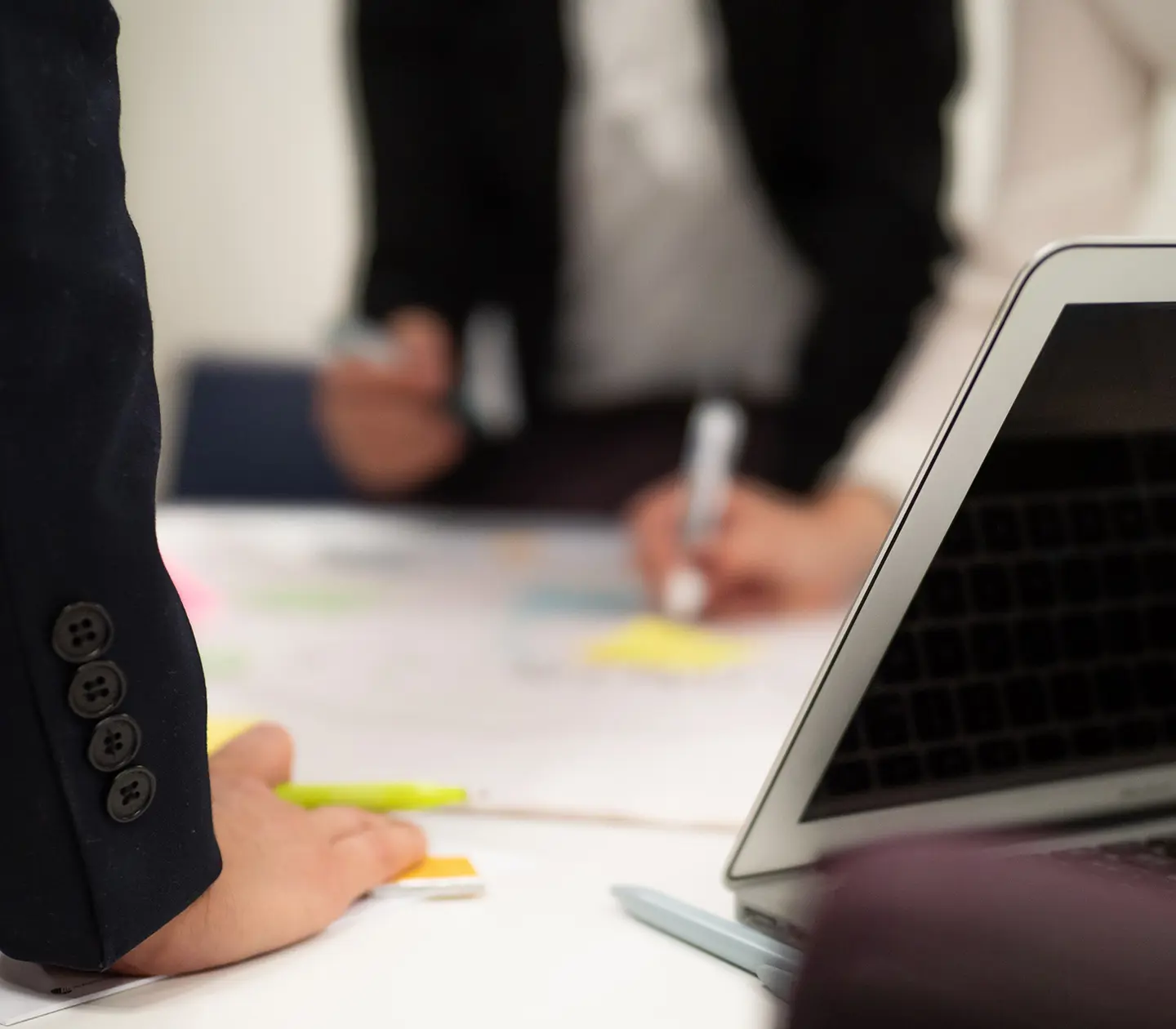 Close-up of people writing post it notes in an office