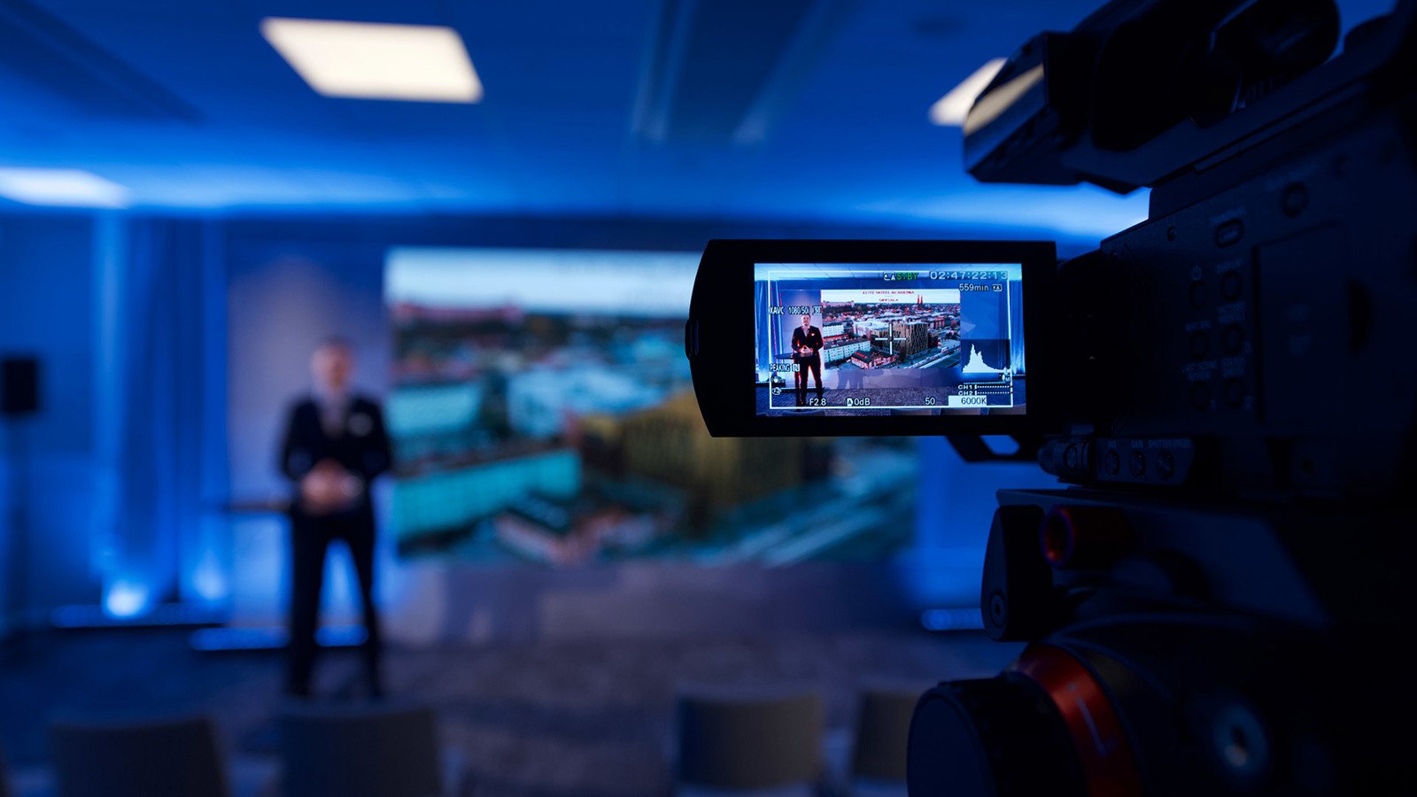 A man holding a presentation and a camera recording him