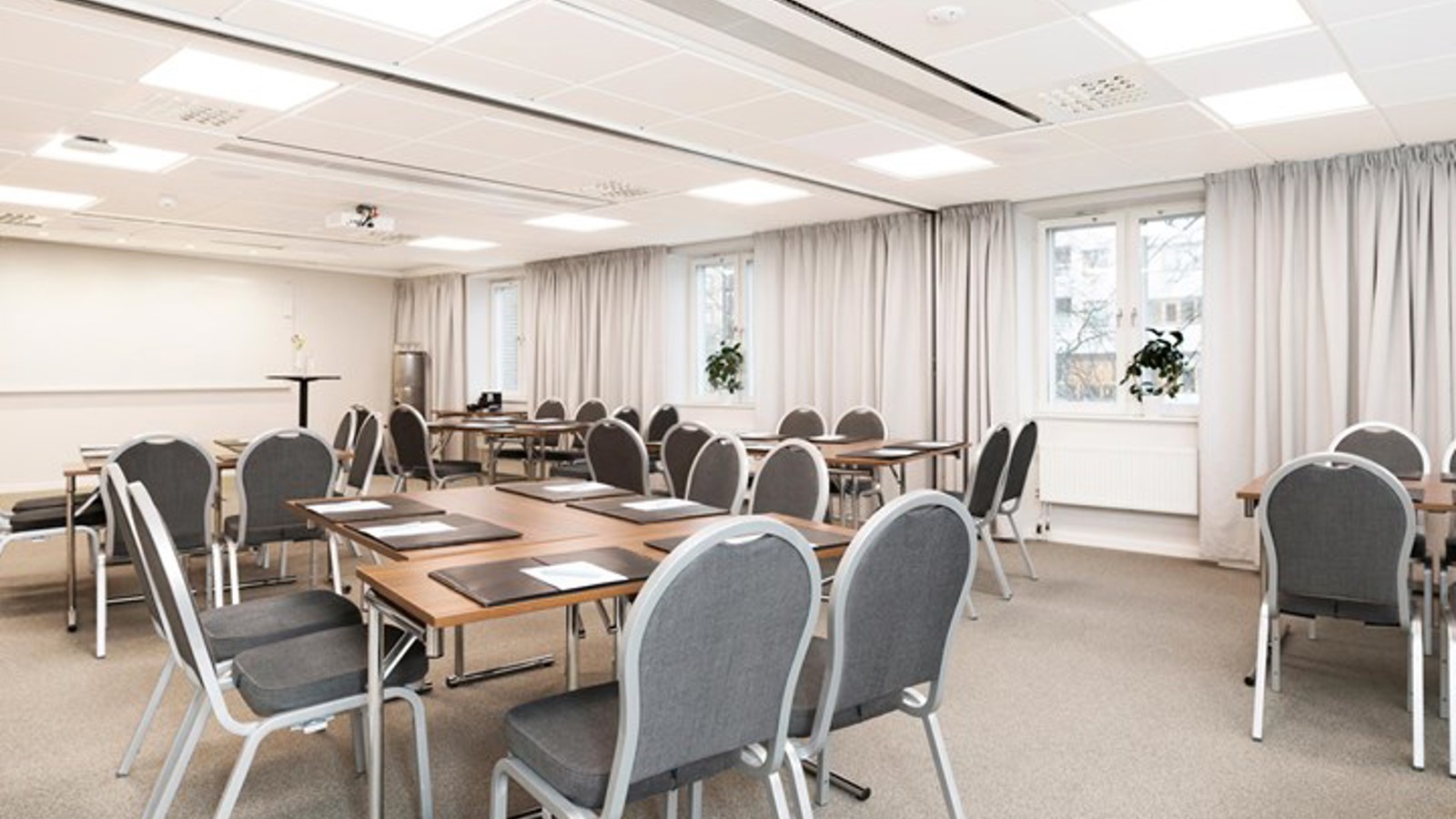White conference room with round tables and chairs