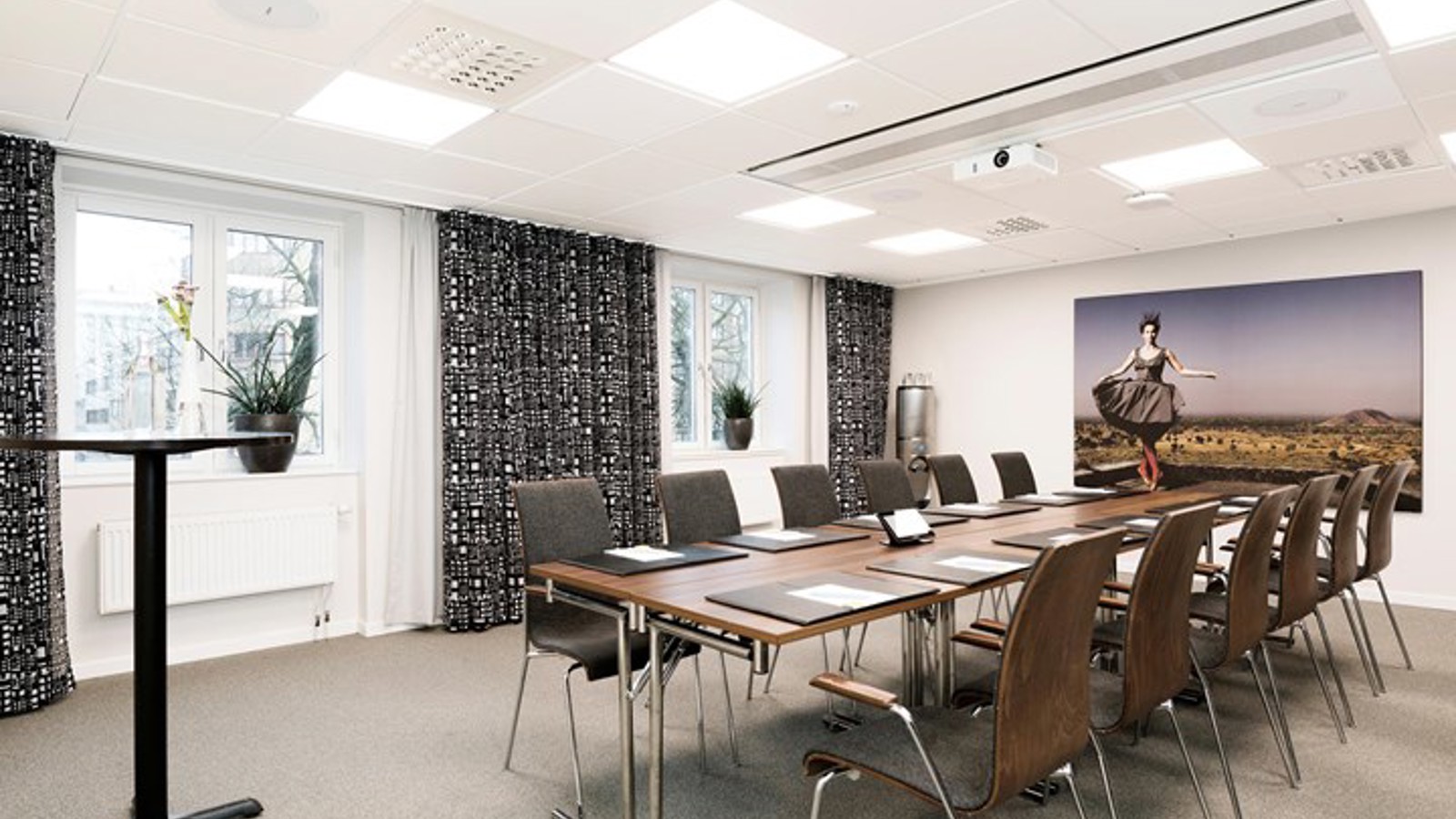 Konferensbord styrelsesittning i konferrensrum med gråa gardiner