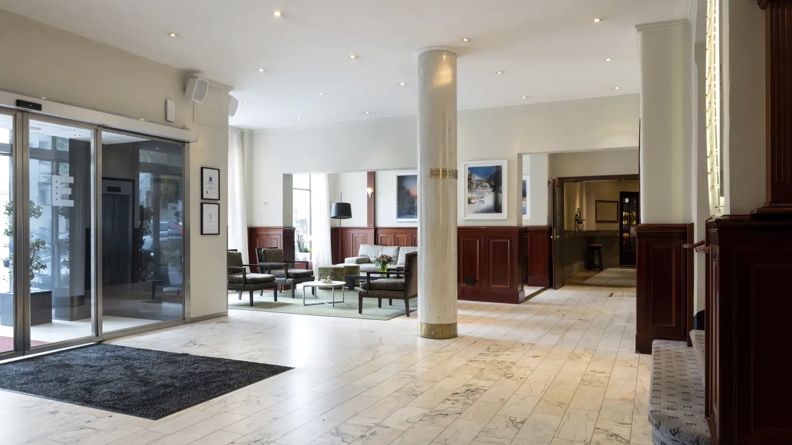Modern lobby with marble floors and elegant furniture in a luxurious hotel environment.