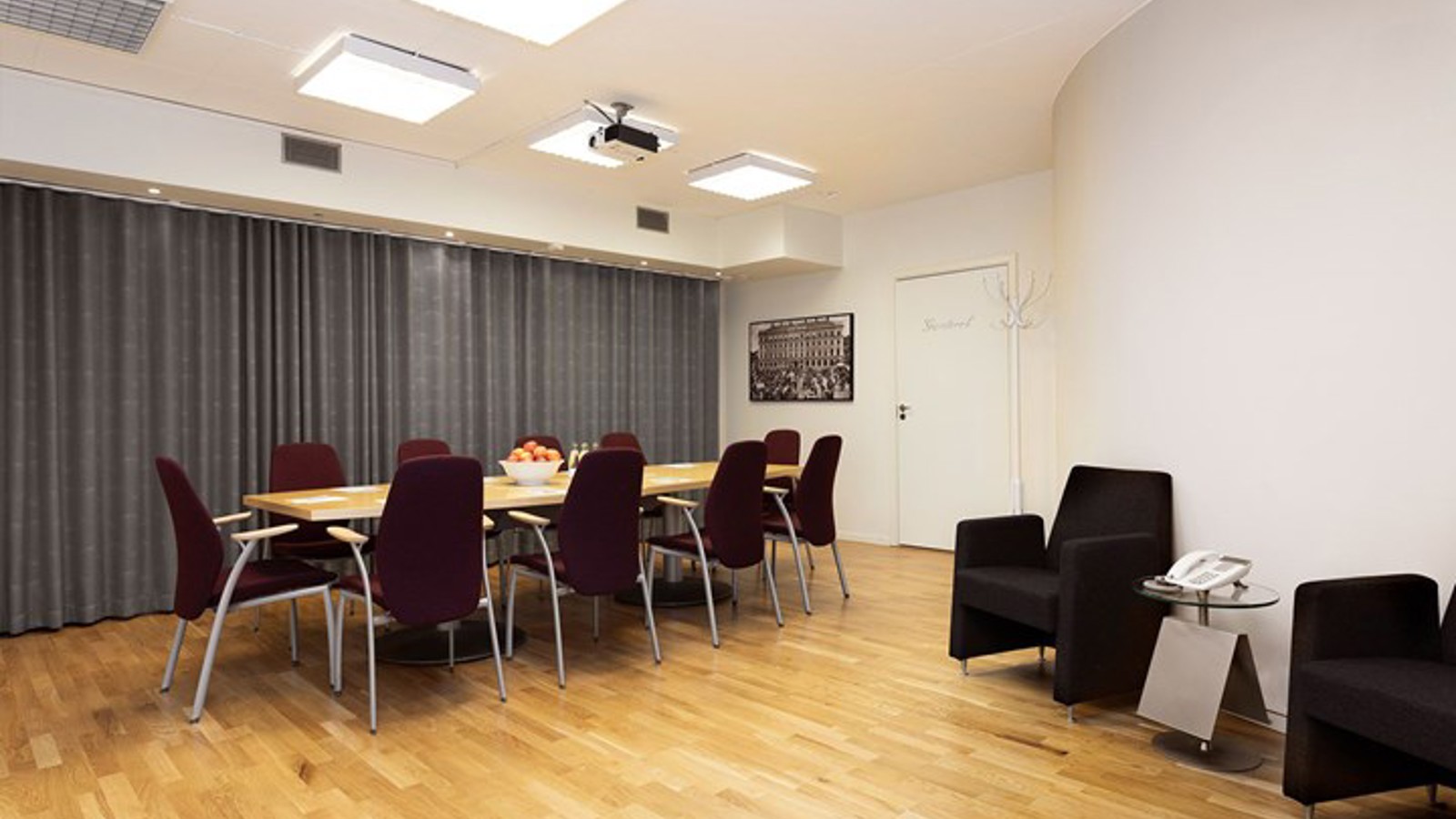Grupprum, mindre konferensrum med styrelsesittning, trägolv och vita väggar