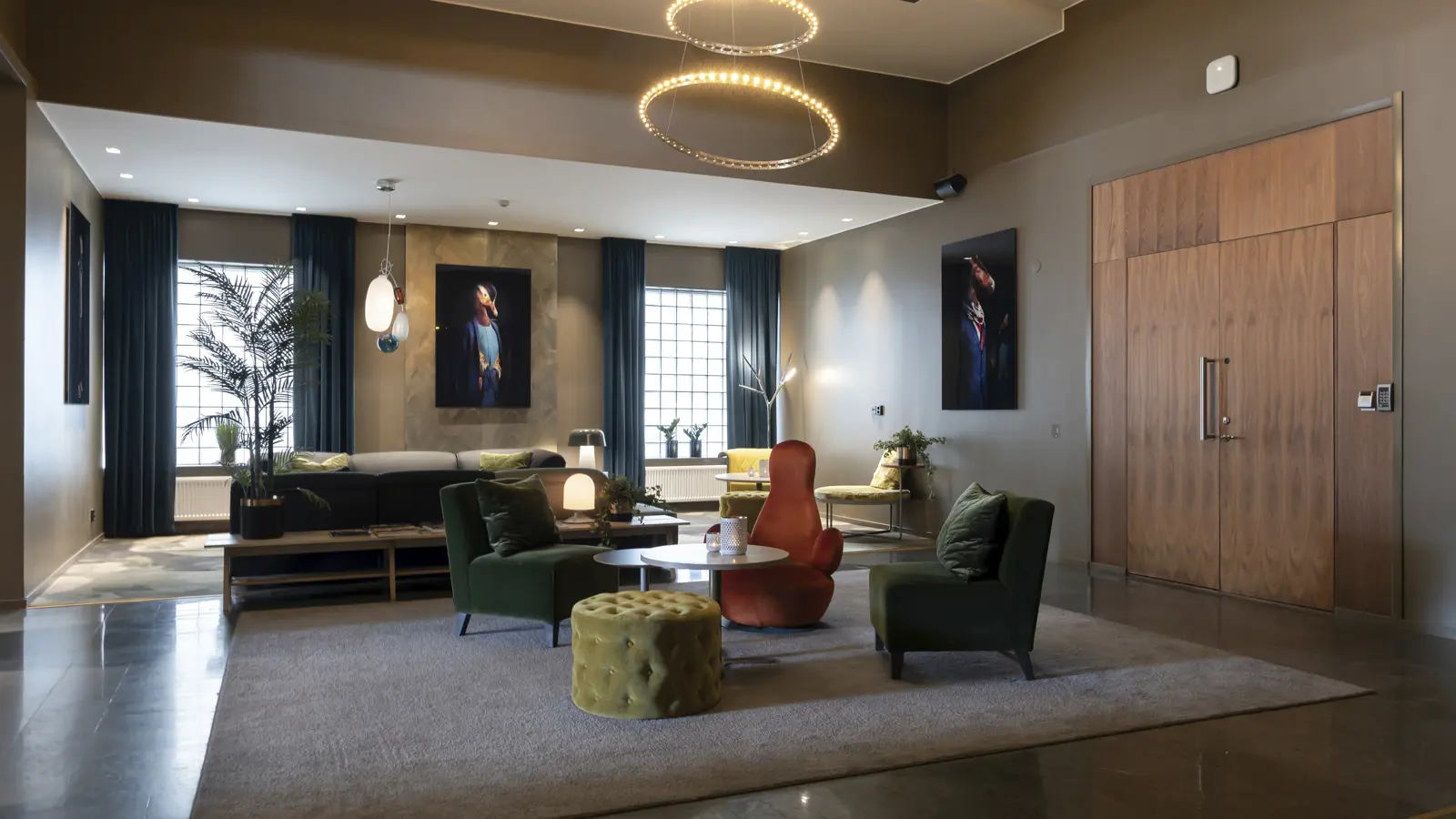 Modern hotel lobby with stylish seating, circular ceiling lights, and contemporary artwork on the walls.