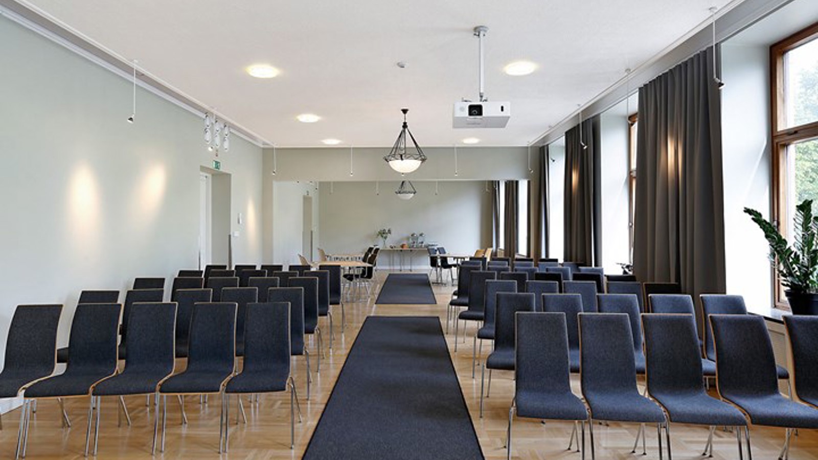 Konferensrum med biosittning, mörka stolar, ljusa väggar och stora fönster