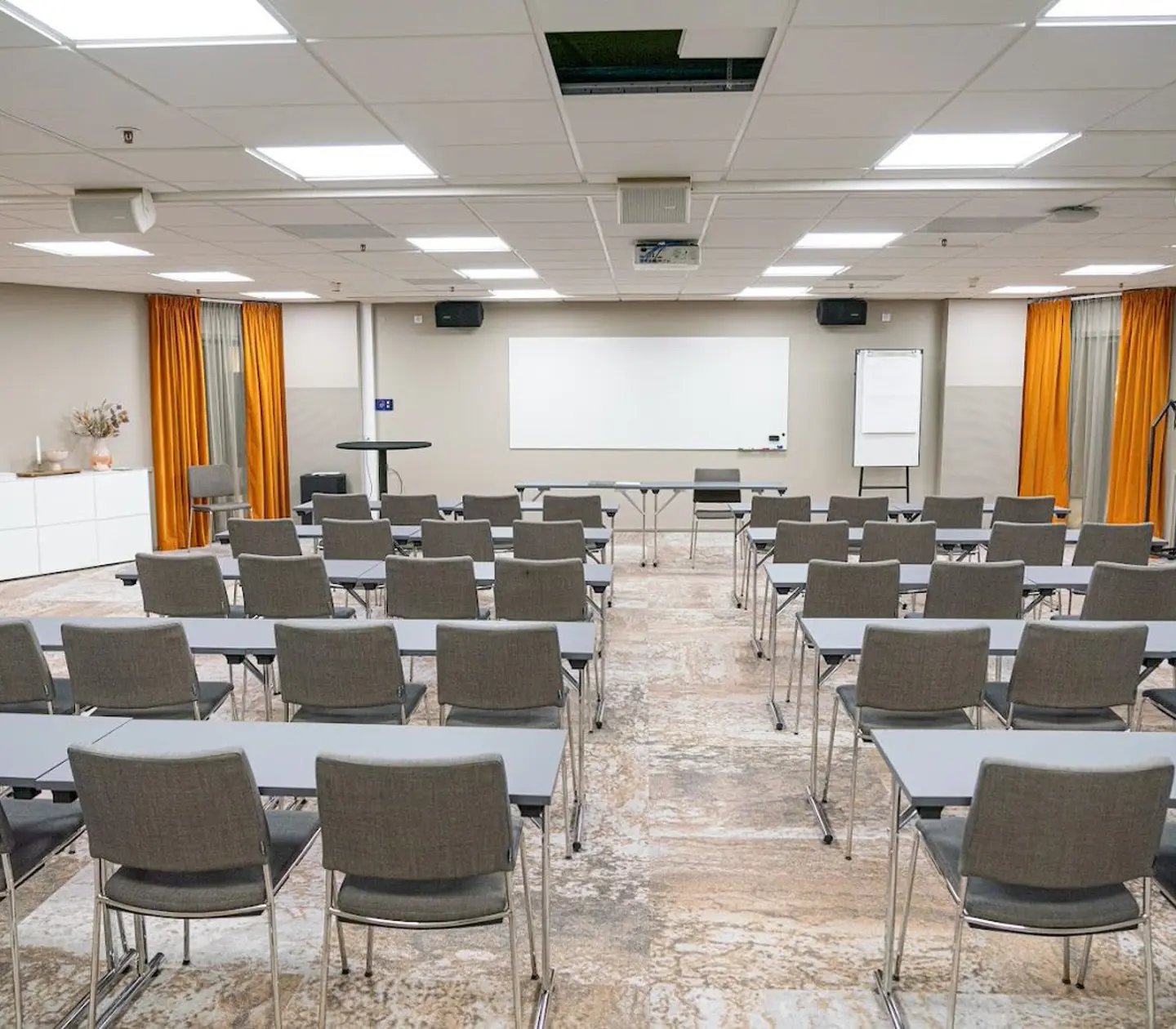 Konferensrum med skolsittning och grå stolar