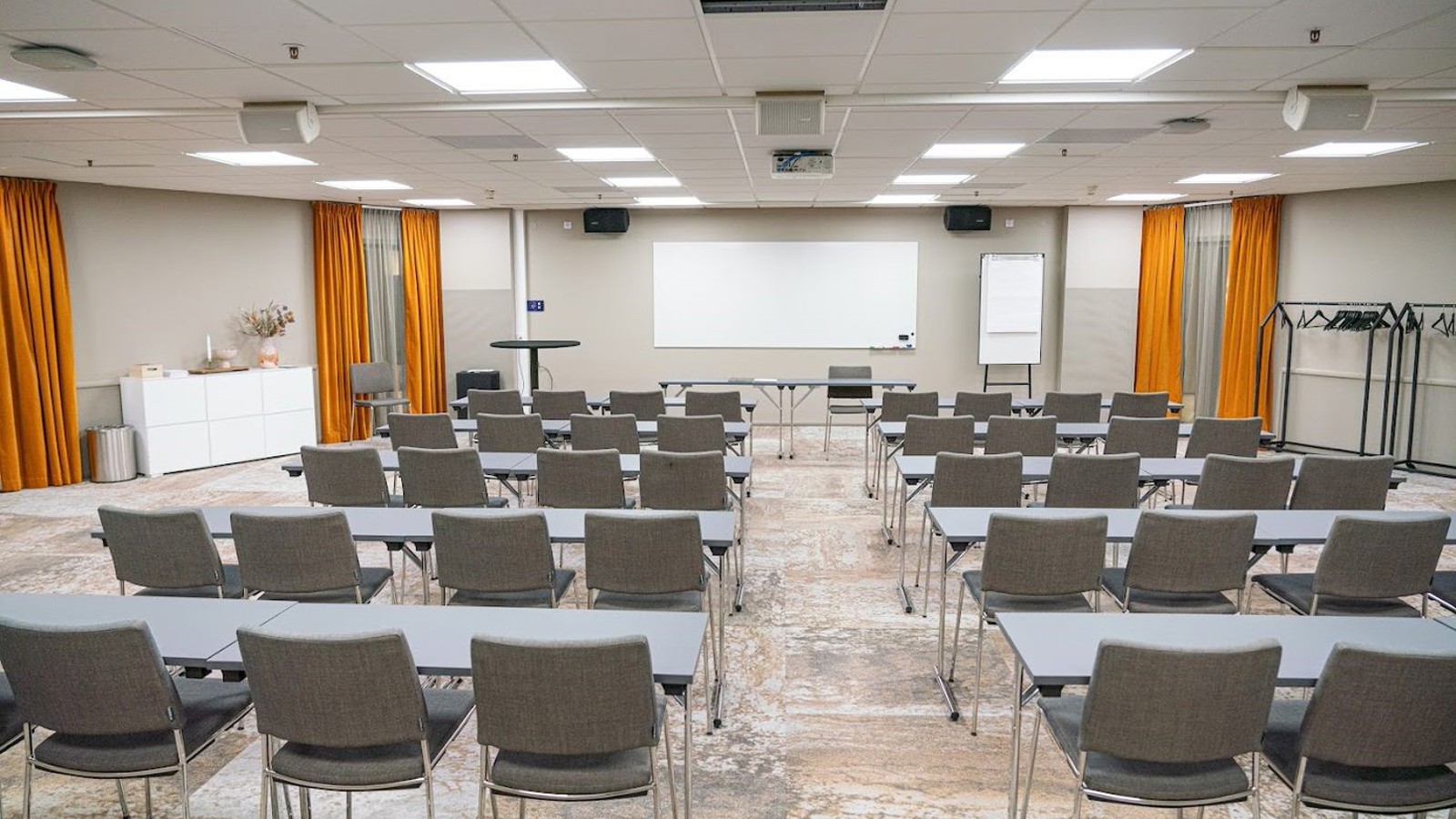 Konferensrum med skolsittning och grå stolar