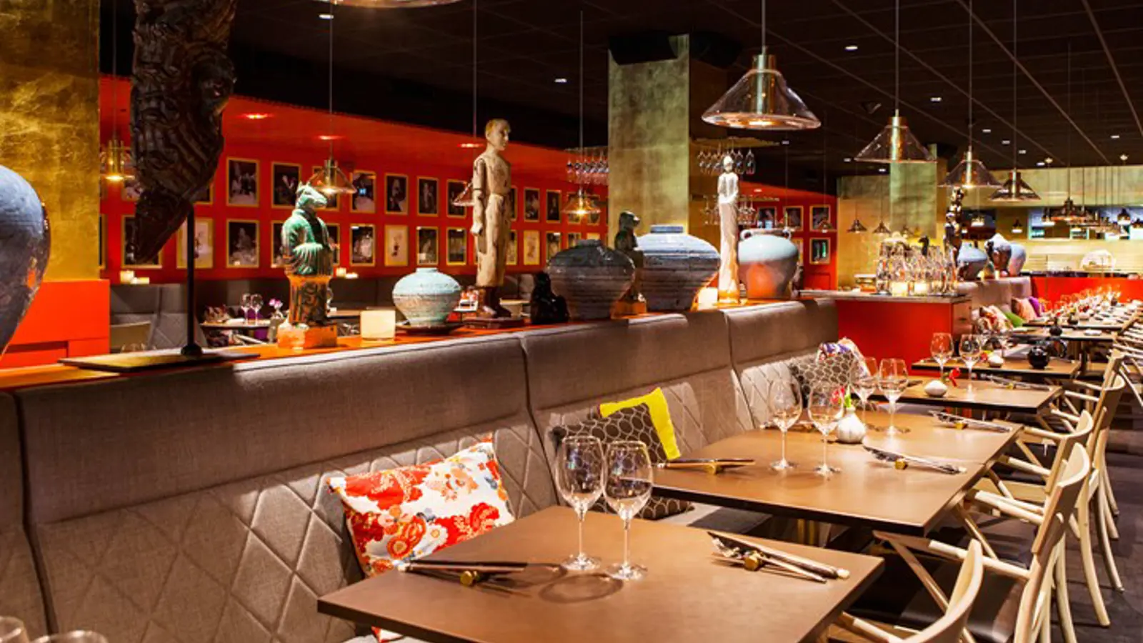 Restaurangmiljö i närbild, mörkbruna bord dukade med vinglas