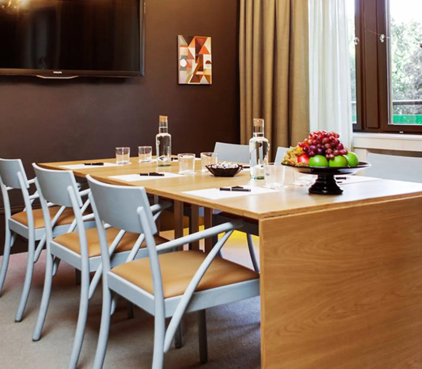 Meeting room with board seating, wooden table and gray chairs