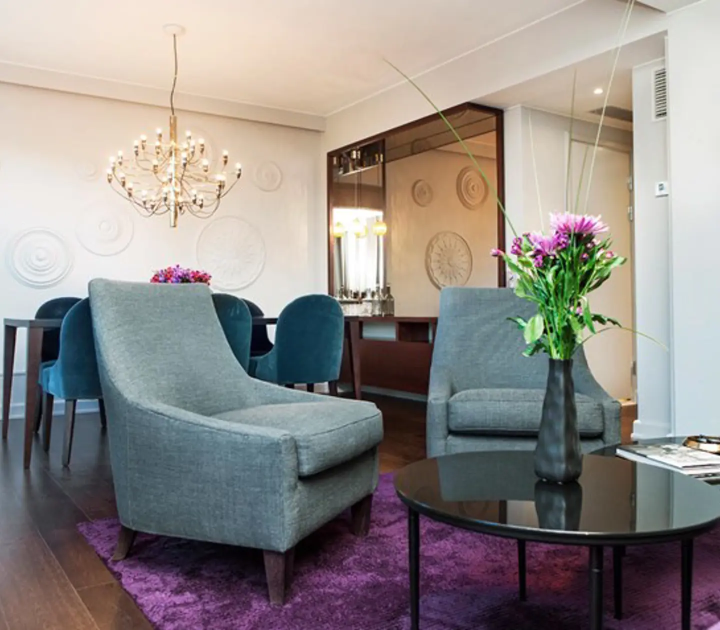 Meeting room with board seating, armchair group, white walls and brown wooden floor