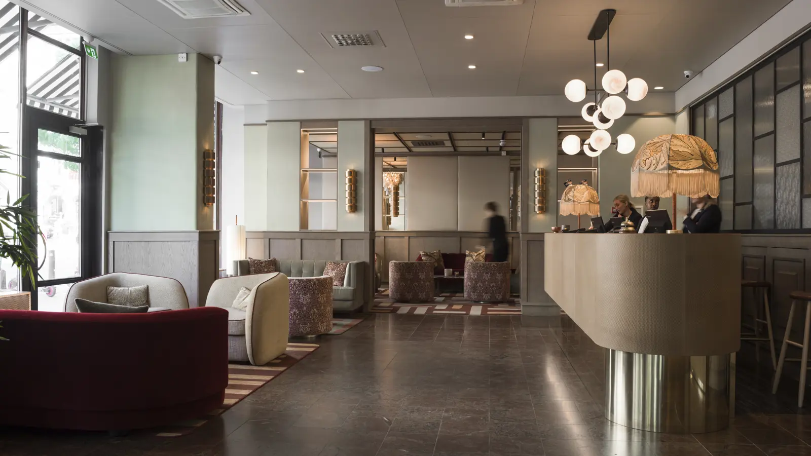 Modern hotel lobby with elegant decor, featuring a sleek reception desk, plush seating, ambient lighting, and stylish furniture.