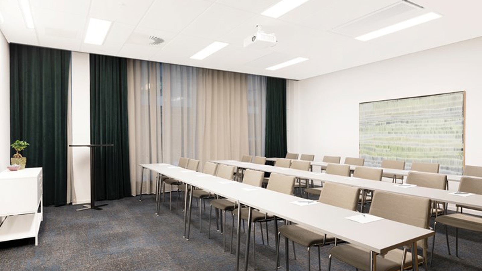 Konferensrum med skolsittning, vita möbler, grå matta och fördragna gardiner