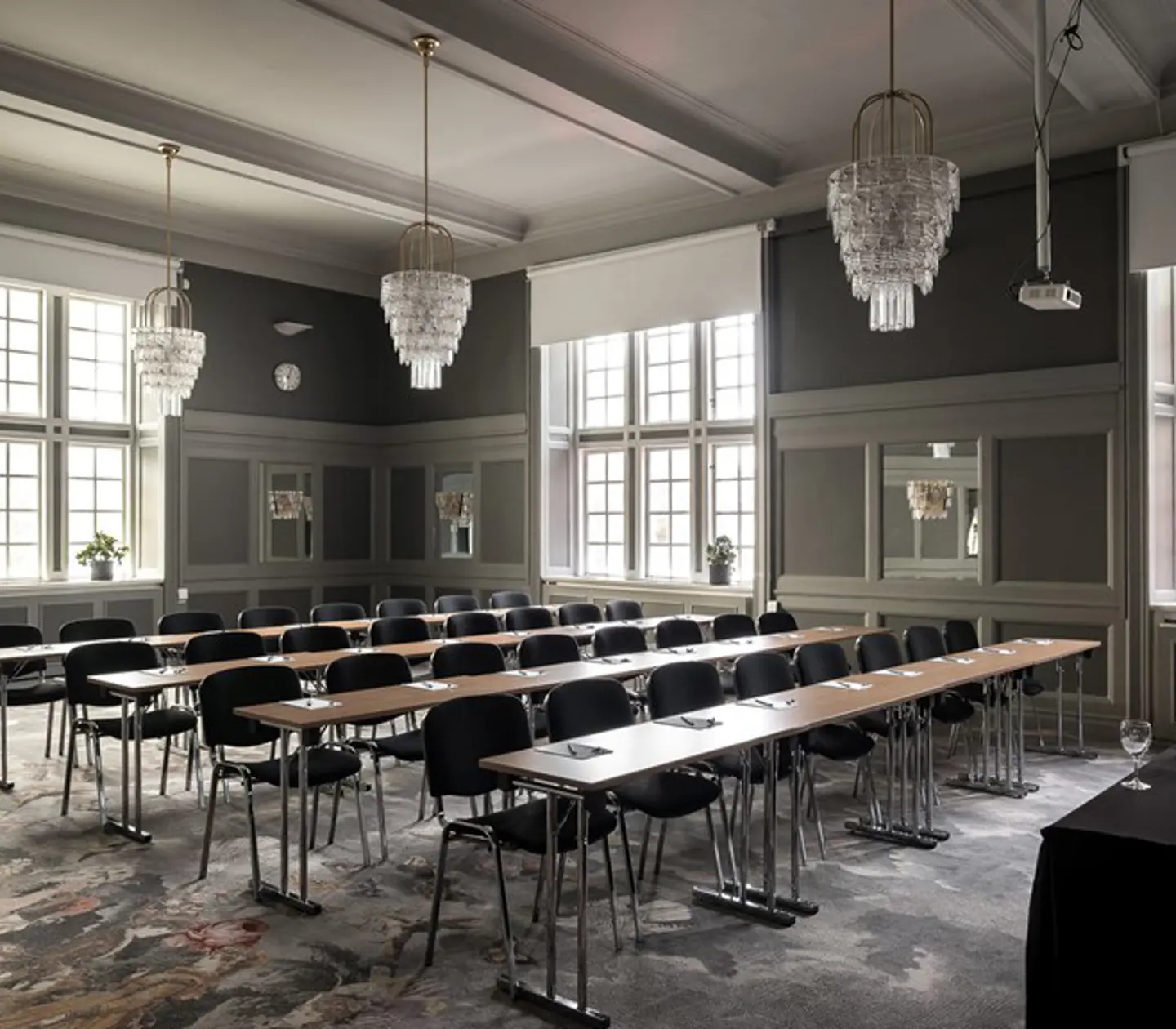 Conference room with many chairs, crystal chandeliers and windows