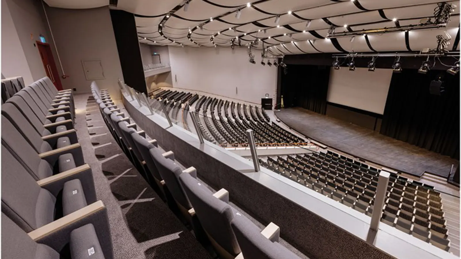 A conference hall with a large screen behind the stage